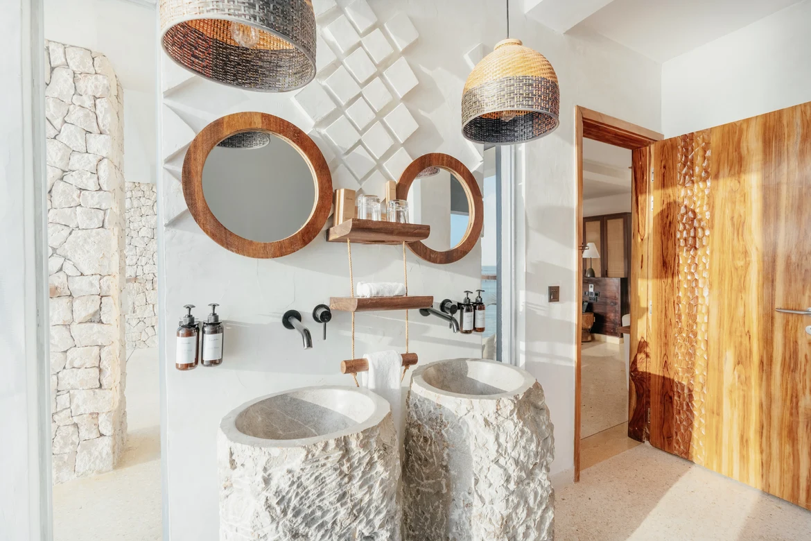 Zwei handgefertigte Steinwaschbecken mit Holzspiegeln und modernen Lichtquellen bei Aldiana