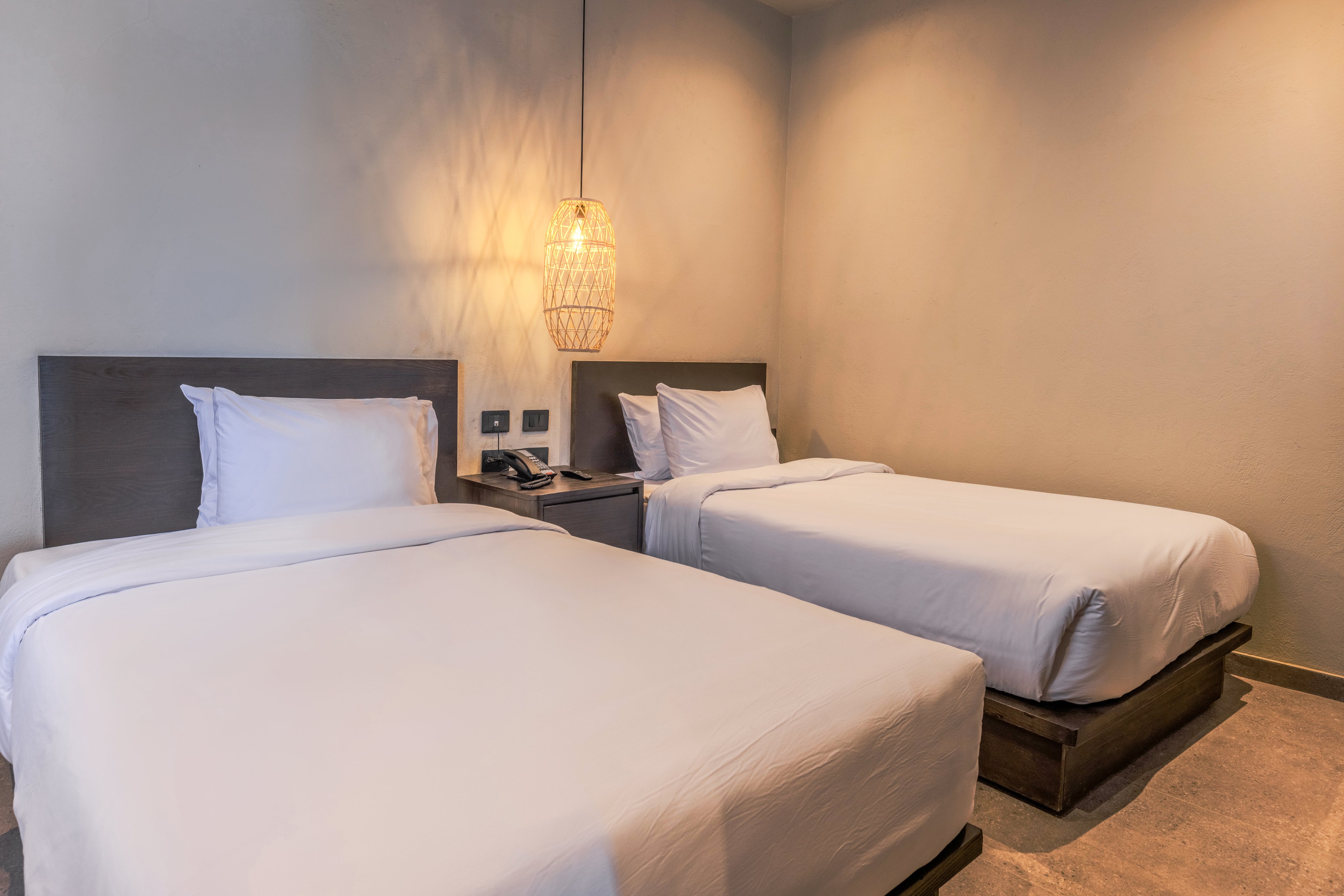 Schlafzimmer mit zwei Betten, modernen Lampen und gemütlichen Betten.