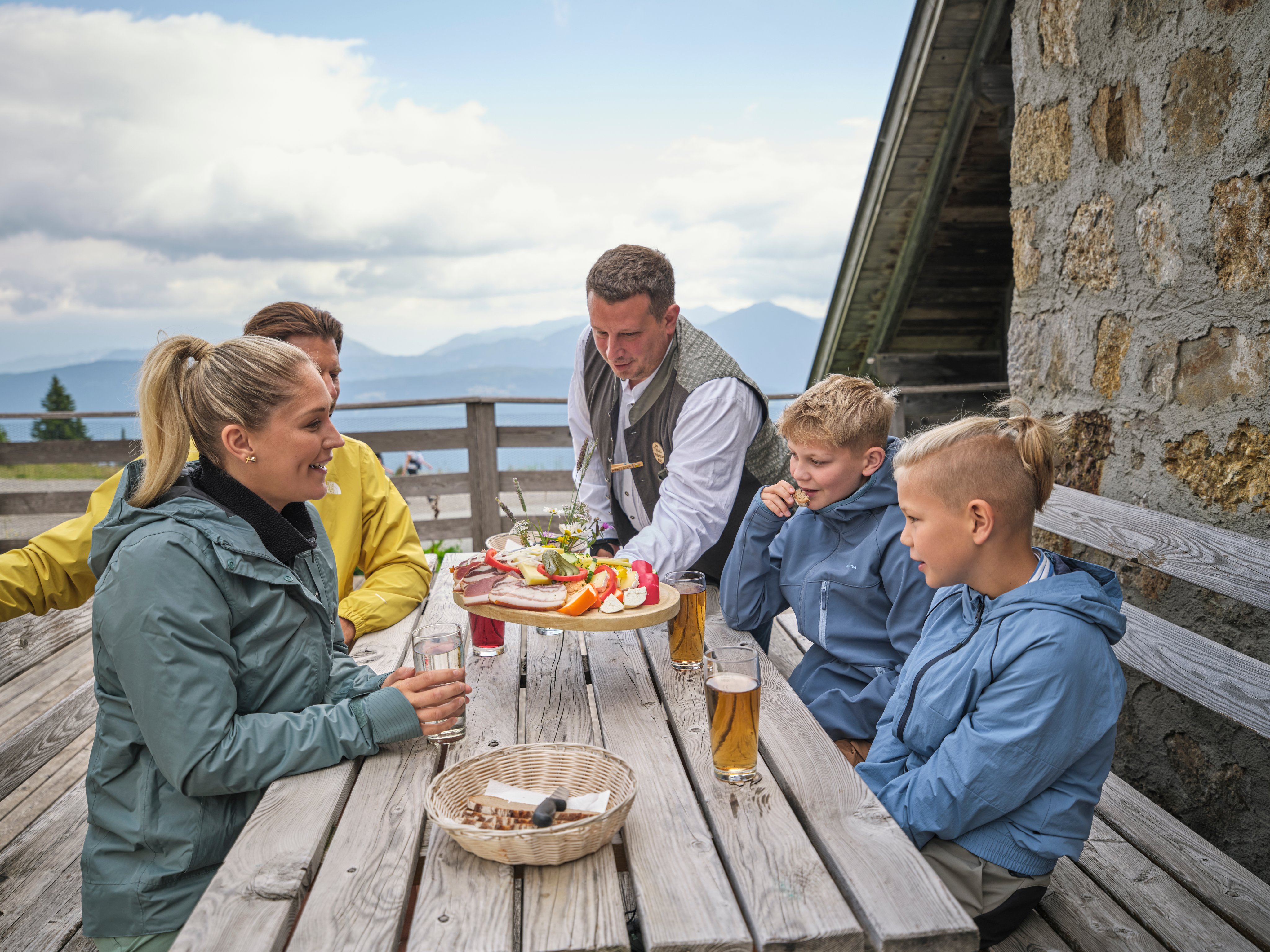 Gruppe von Menschen beim Essen auf der Terrasse eines Aldiana Premium Clubs mit Bergblick