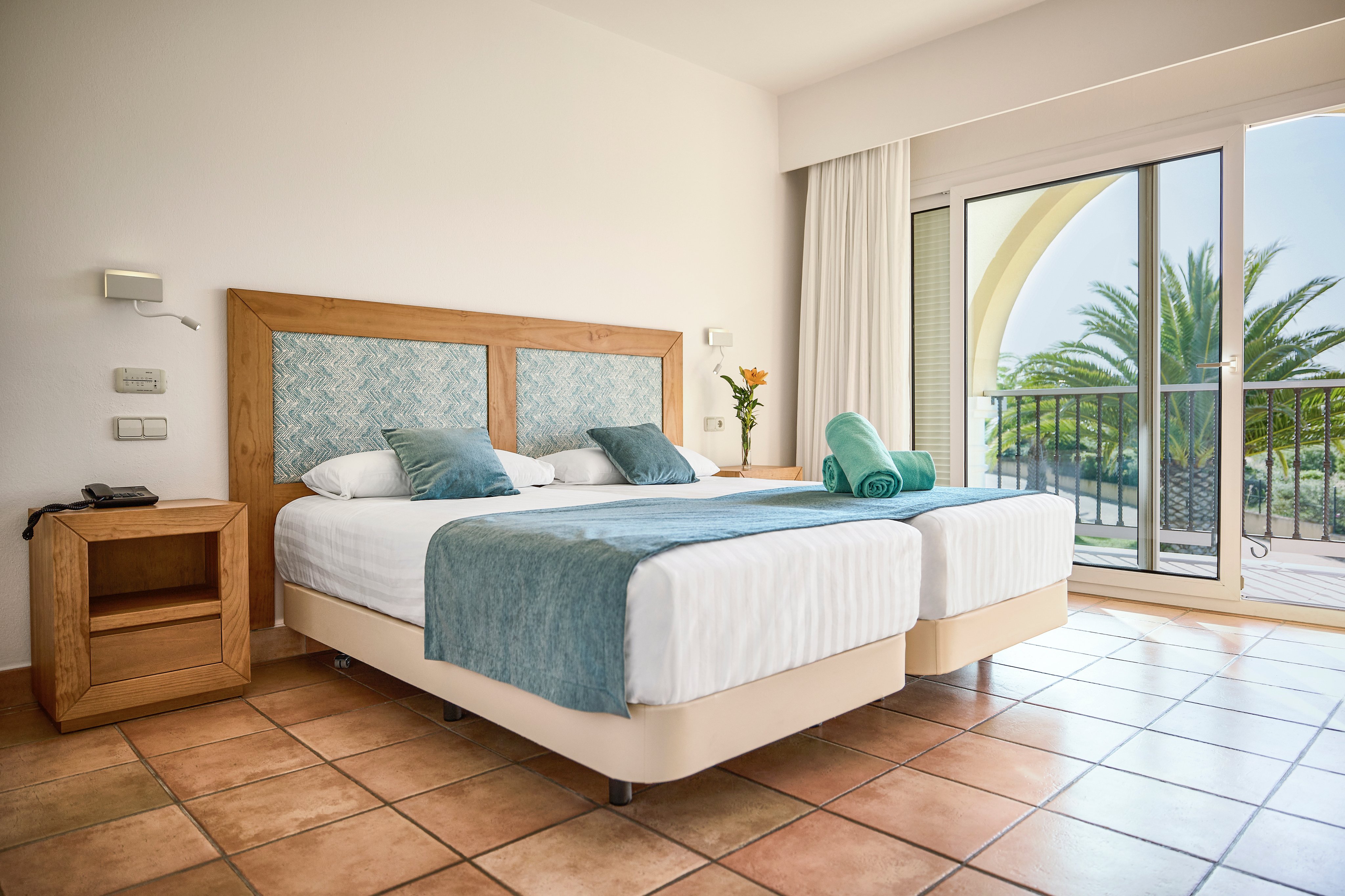 Schlafzimmer im Premium Cluburlaub bei Aldiana mit klasischem Komfort und Blick auf Balkon