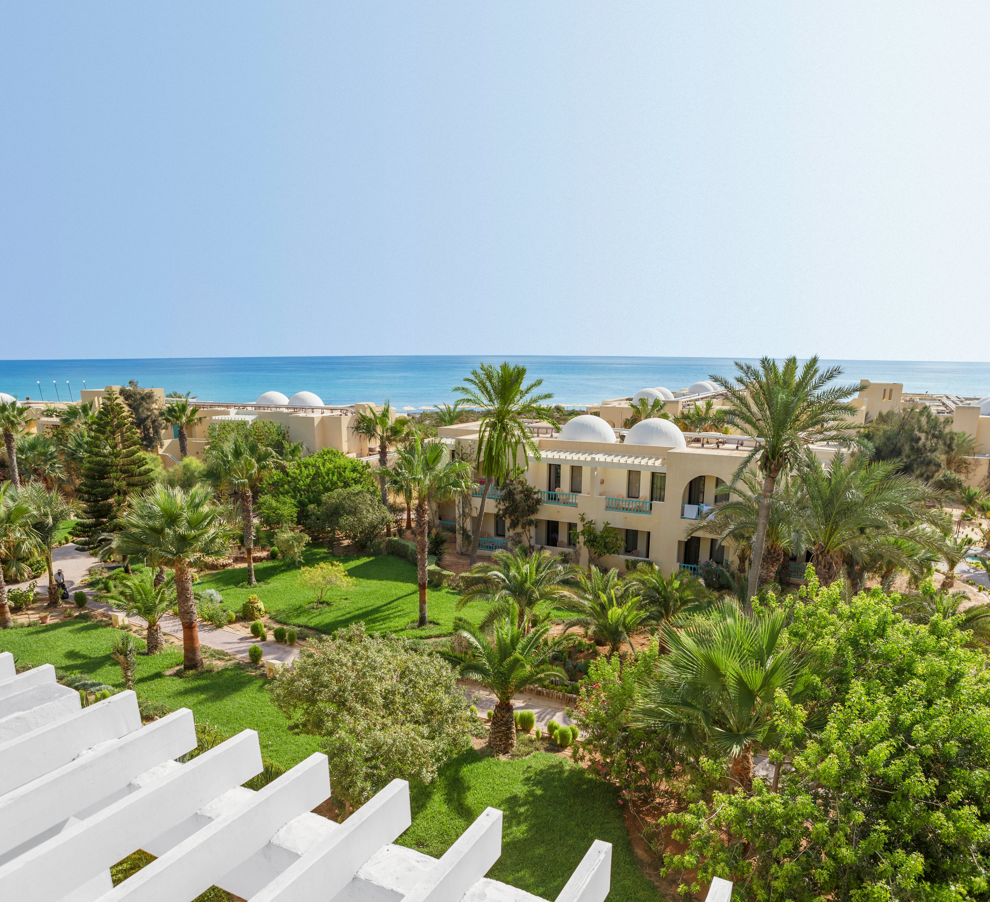 Blick auf grüne Gärten und mediterrane Gebäude bei Aldiana Cluburlaub in sonniger Lage