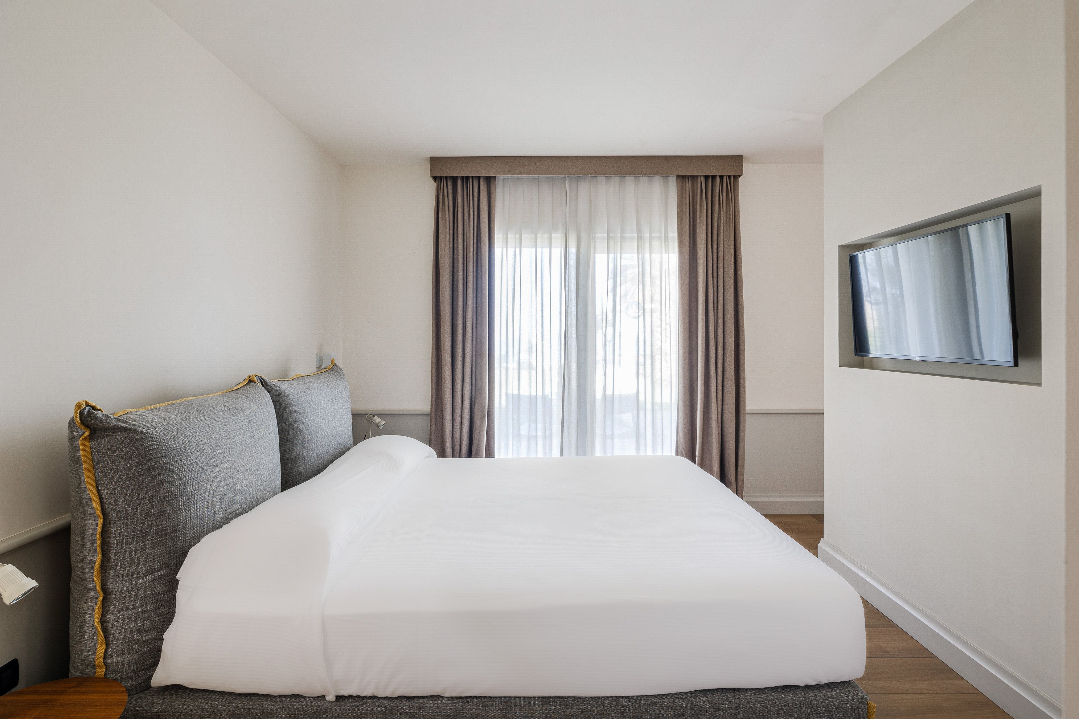 Elegantes Hotelzimmer bei Aldiana mit großem Bett und Fernseher, heller Raum für Premium Cluburlaub