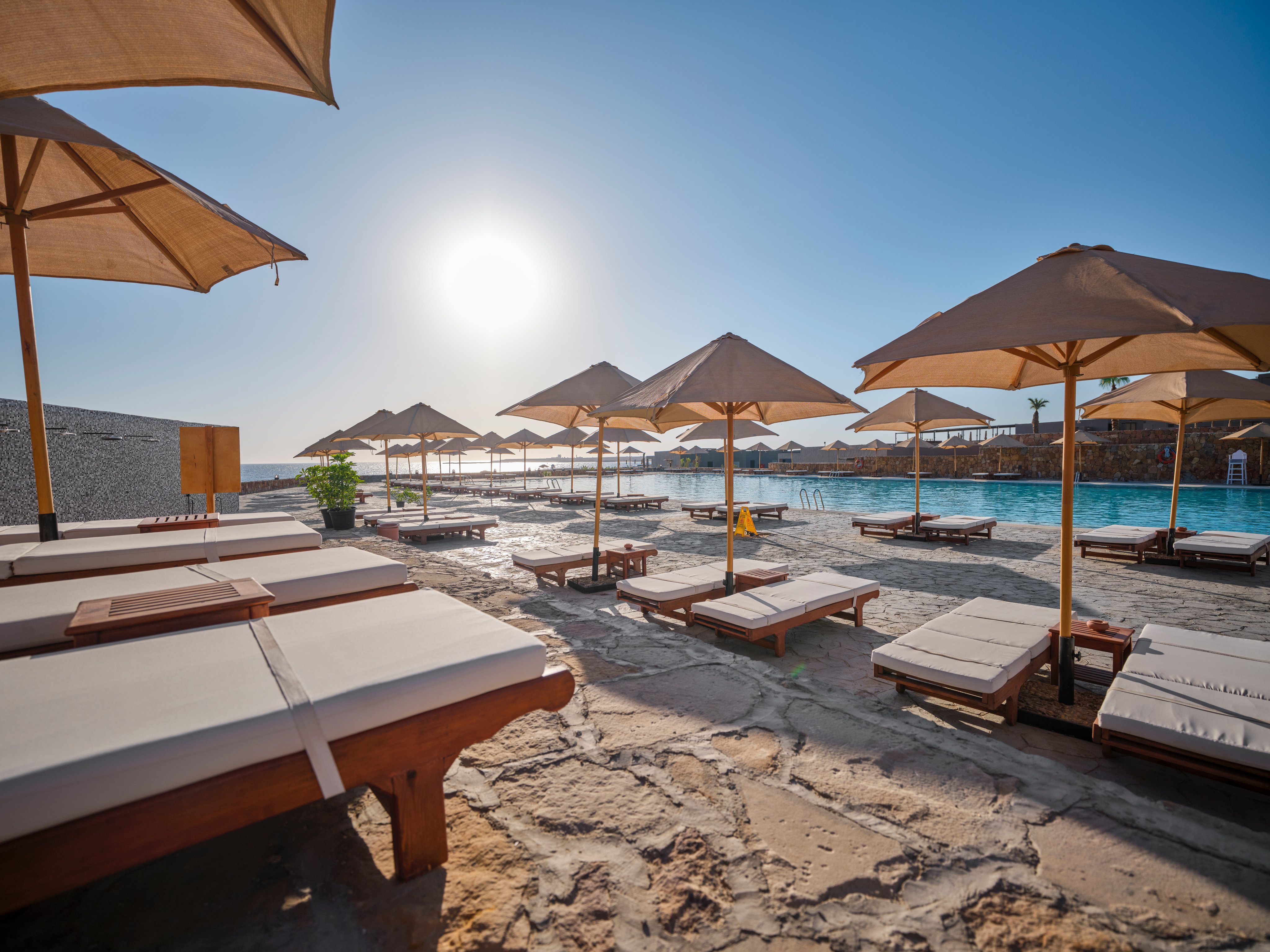 Entspannen am Pool mit Sonnenschirmen bei Aldiana in schöner Urlaubsatmosphäre.