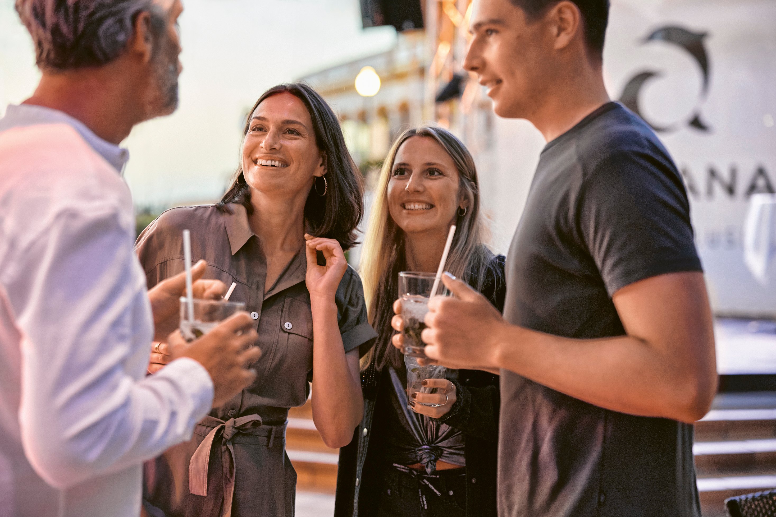 Mehrere Personen bei einem geselligen Gespräch mit Getränken im Outdoor-Bereich bei Aldiana hochwertiger Cluburlaub