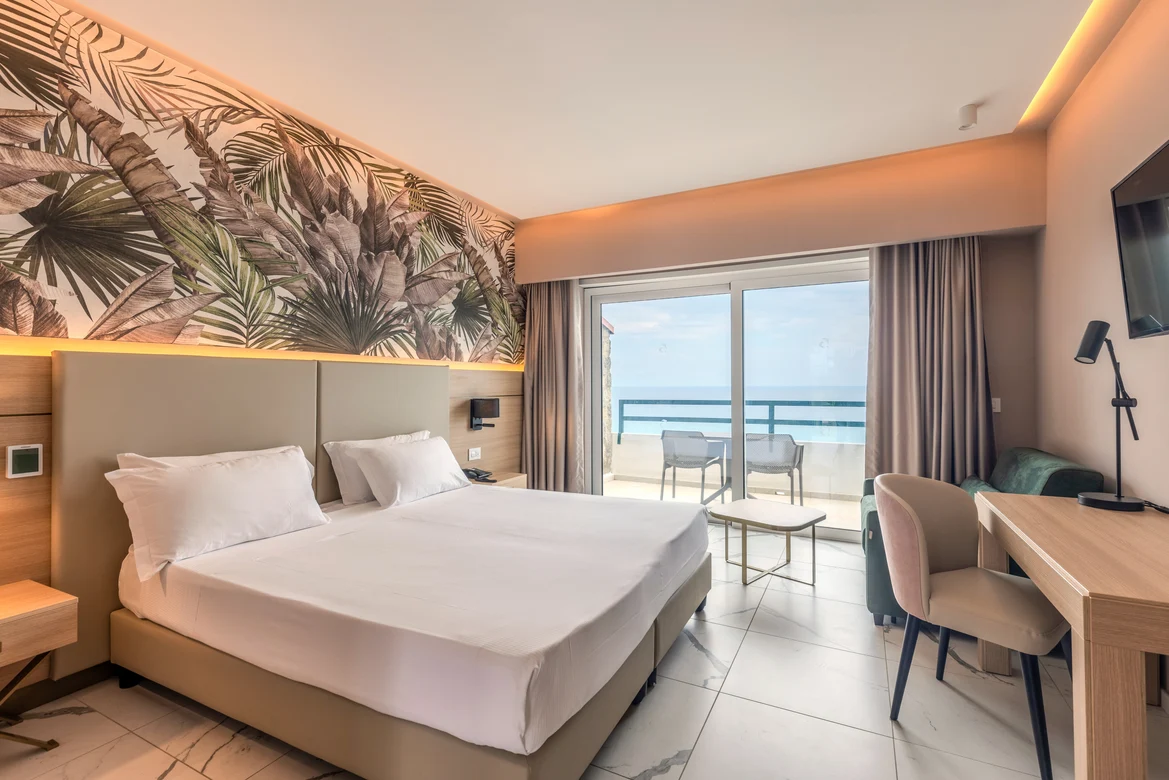 Helles Hotelzimmer mit Balkon, Meerblick, gemütlicher Einrichtung und eleganter Ausstattung