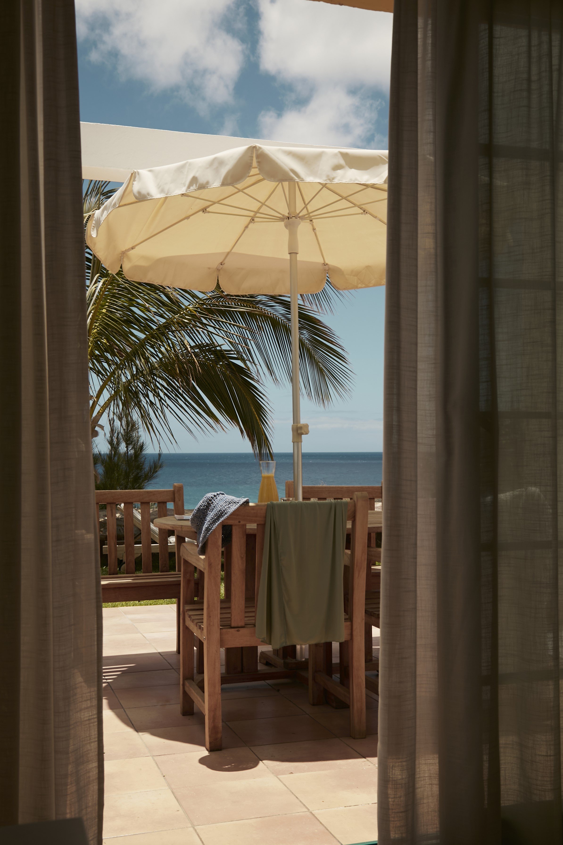 Ansicht eines beach Resorts mit Sonnenschirm, Palmen und Blick auf das Meer bei Aldiana