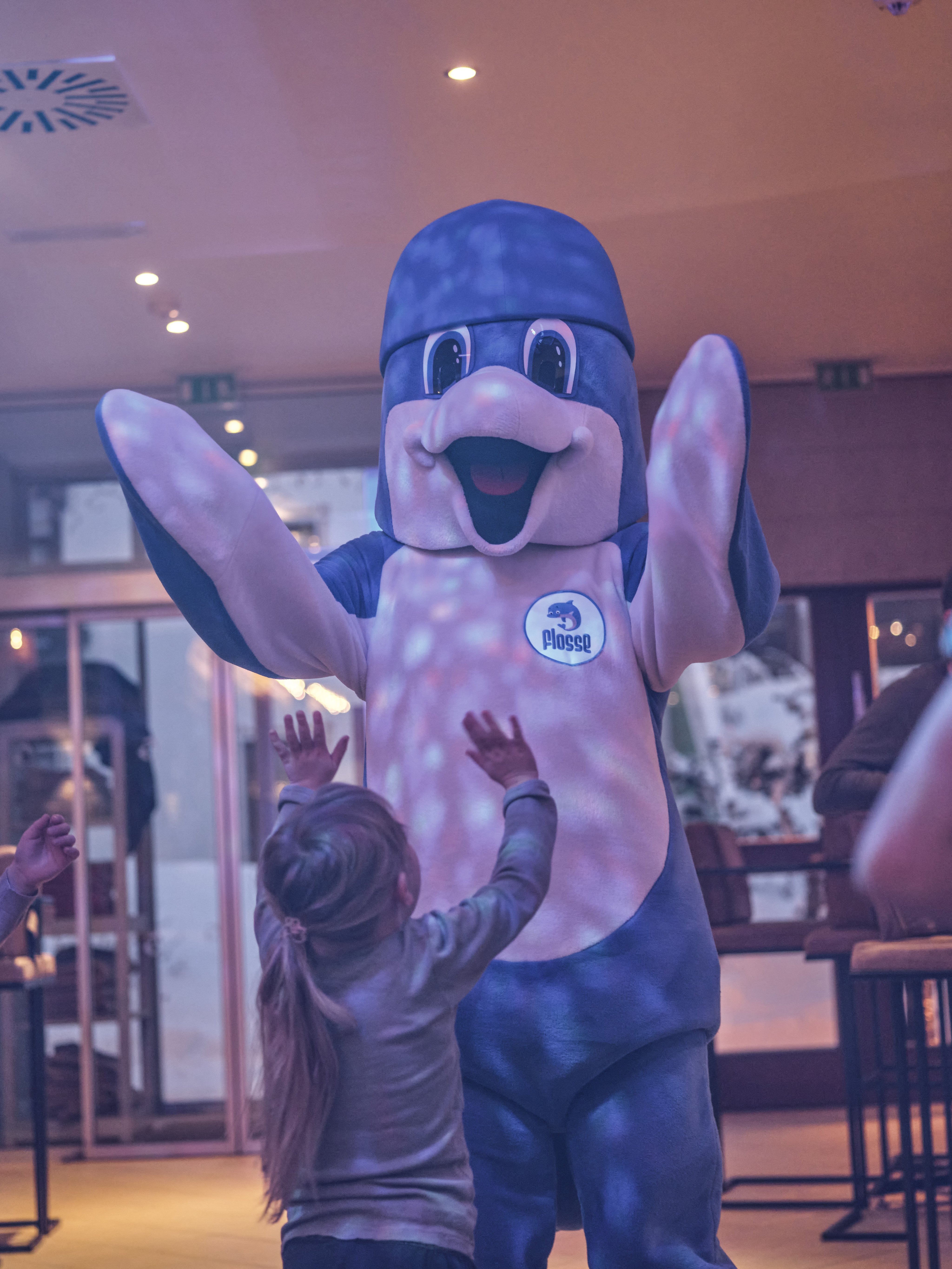 Costumed mascot begrüßt lachende Kinder bei Aldiana, einem Premium Cluburlaub Anbieter