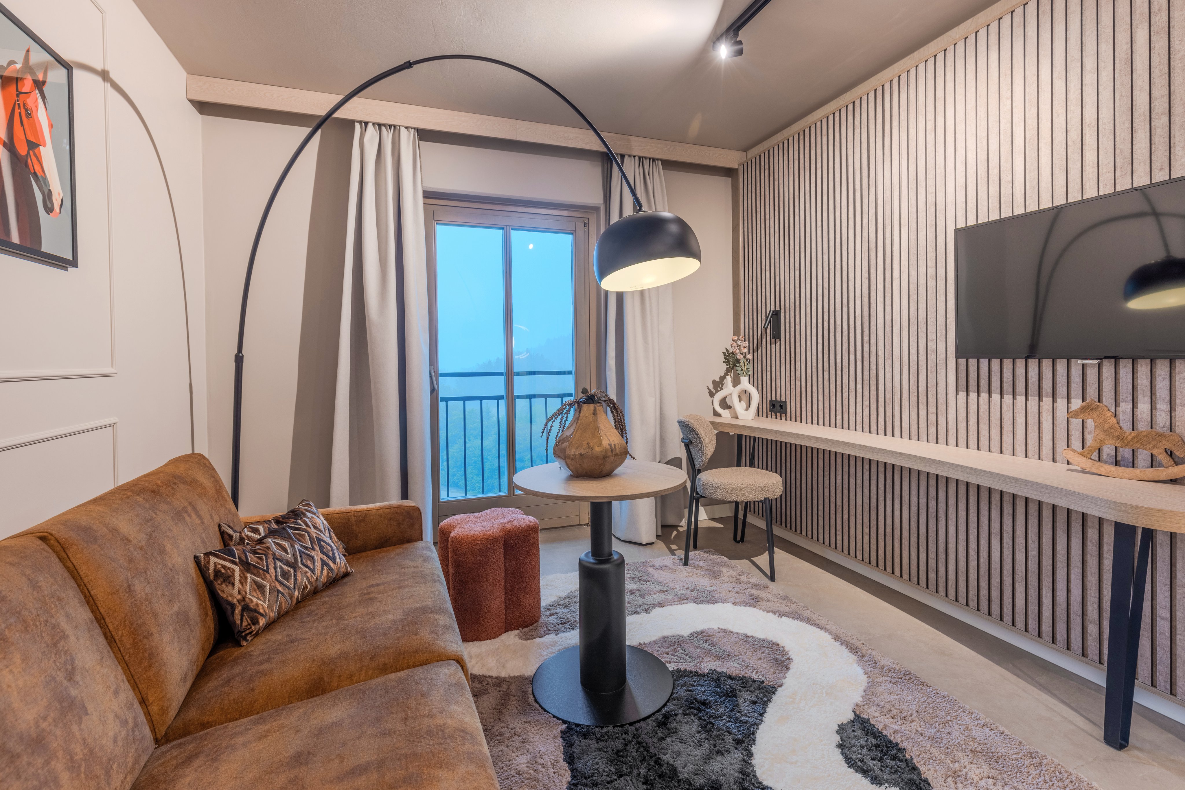 Geräumiges Wohnzimmer mit Sofa, Stehleuchte, Tisch und Balkon bei Aldiana Urlaub