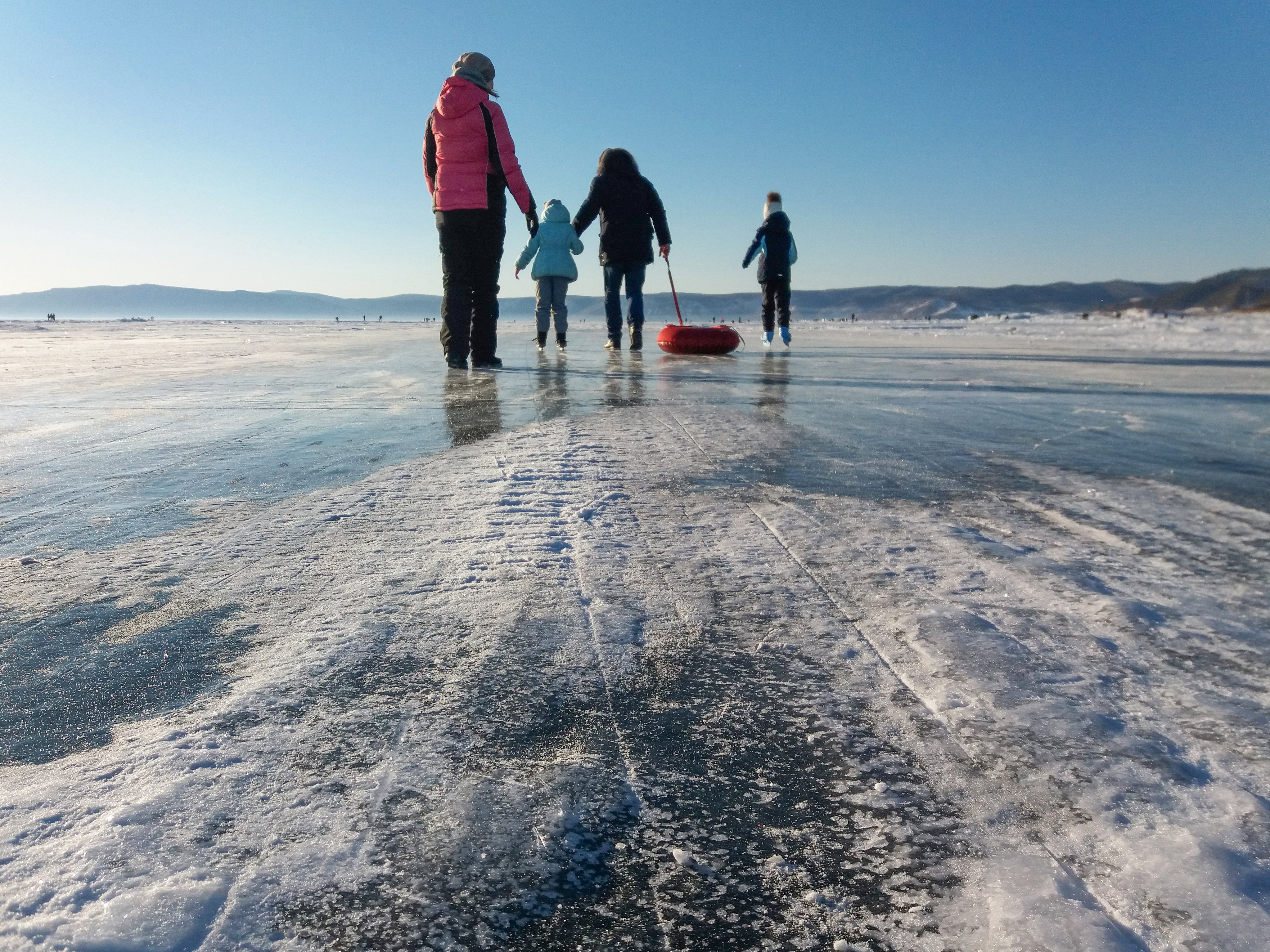 Familie geht auf gefrorenem See spazieren.
