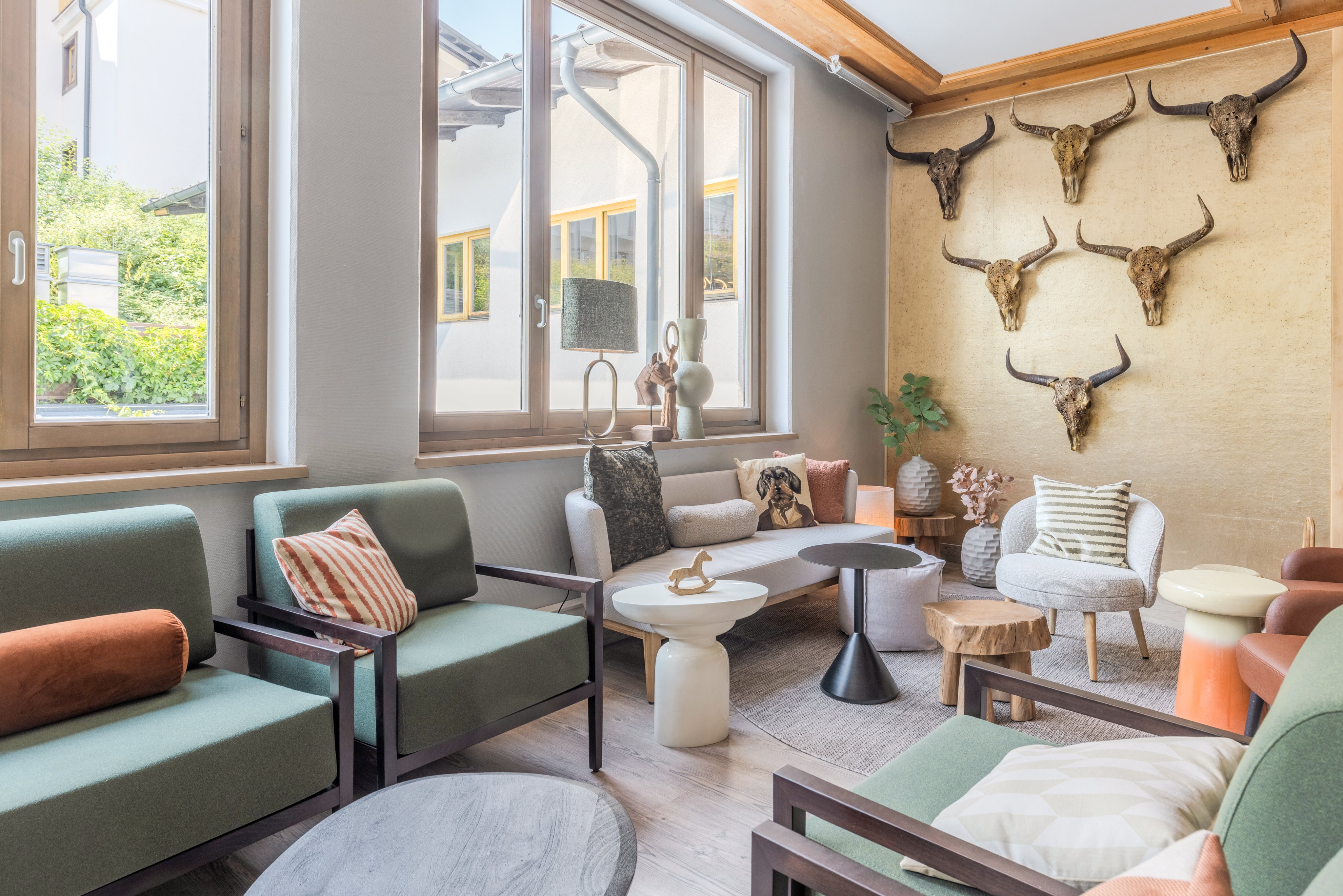 Gemütliches Lounge mit Sesseln, Couchtisch und Wanddekoration aus Geweihen, modernes Design