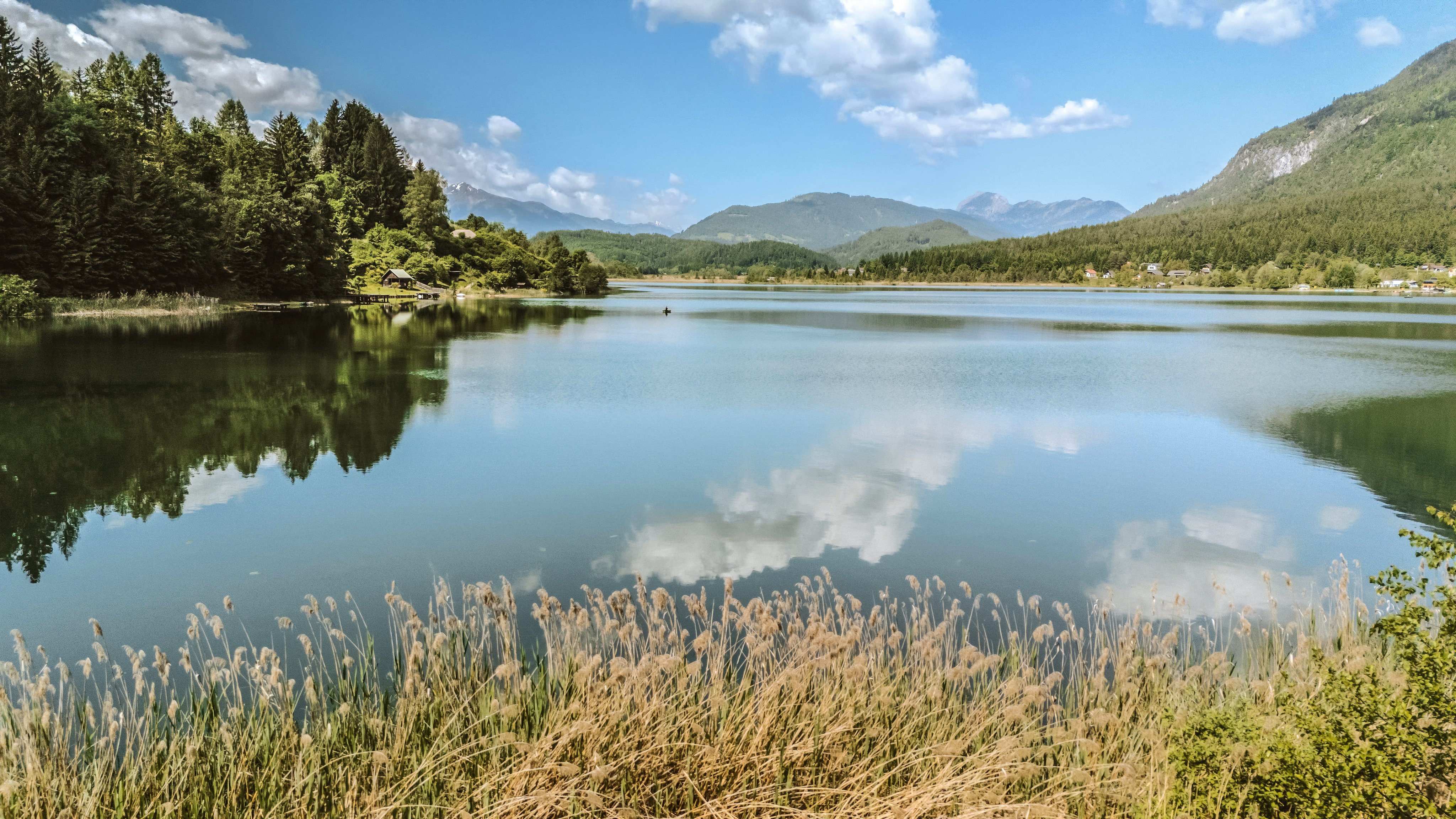 Ein ruhiger See umgeben von Bäumen und Bergen, ideal für einen Premium Cluburlaub bei Aldiana