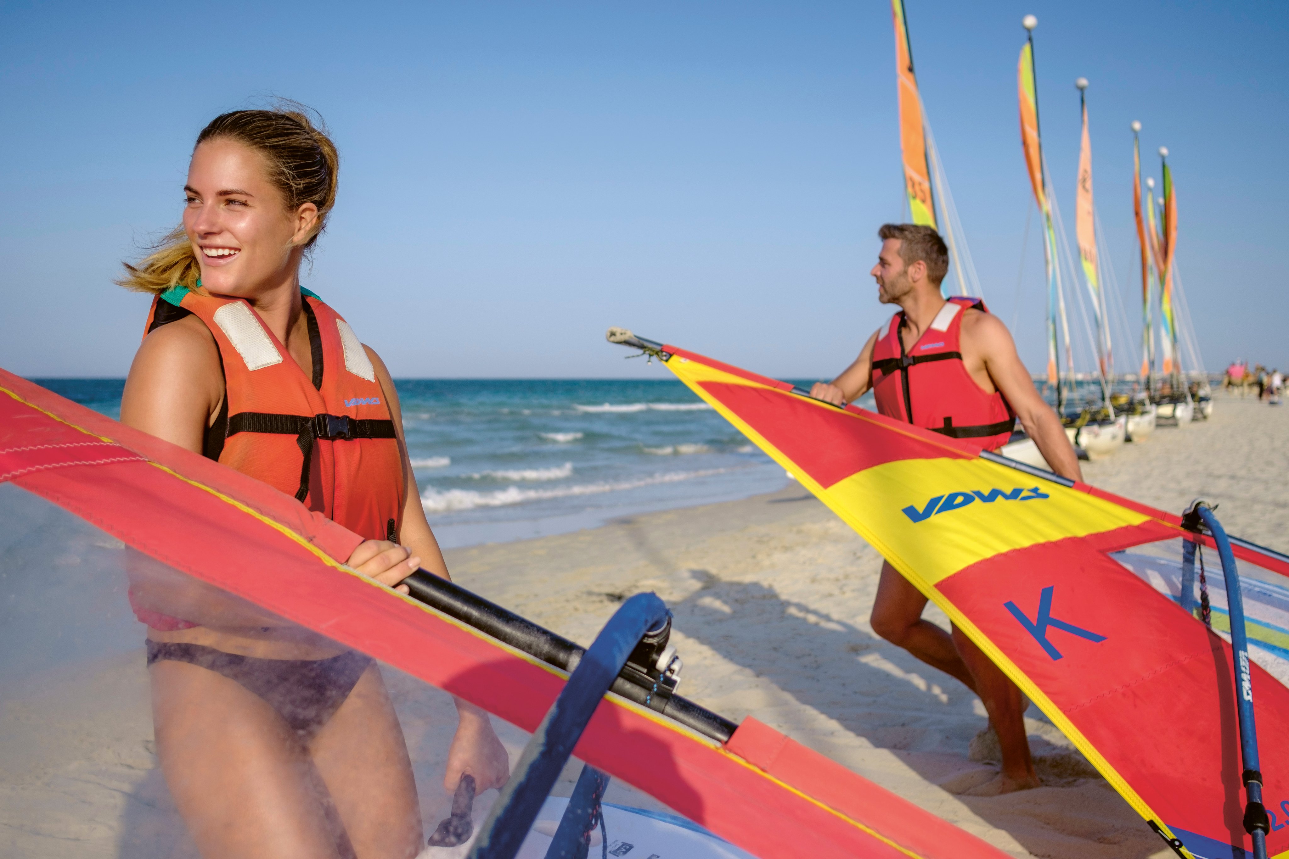 Menschen bereiten sich auf Windsportaktivitäten am Strand vor bei einem Premium Cluburlaub