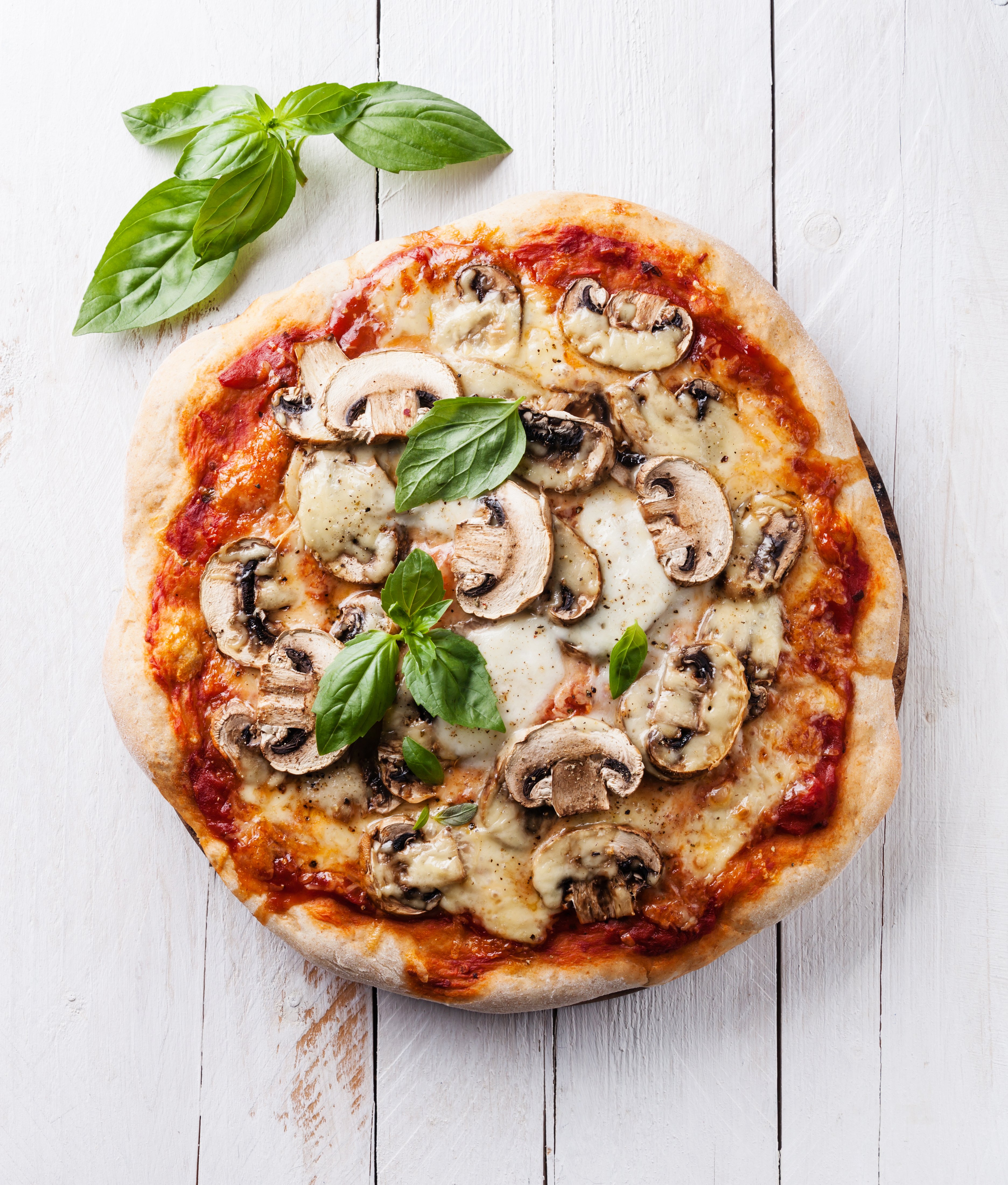 Ein leckere Pilzpizza mit Basilikum, perfekt für einen Premium Cluburlaub von Aldiana