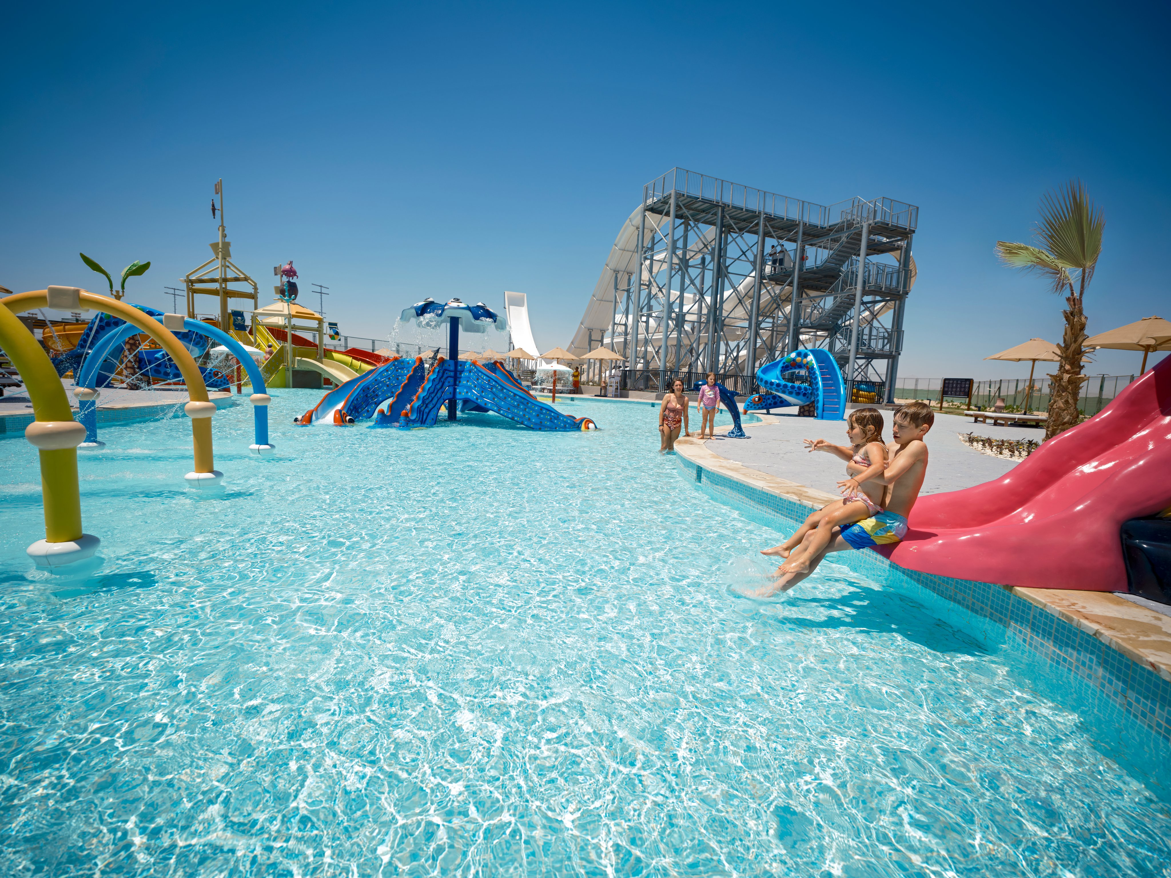 Kinder und Erwachsene im Wasserpark bei Aldiana mit Wasserrutschen und Sonnenliegen