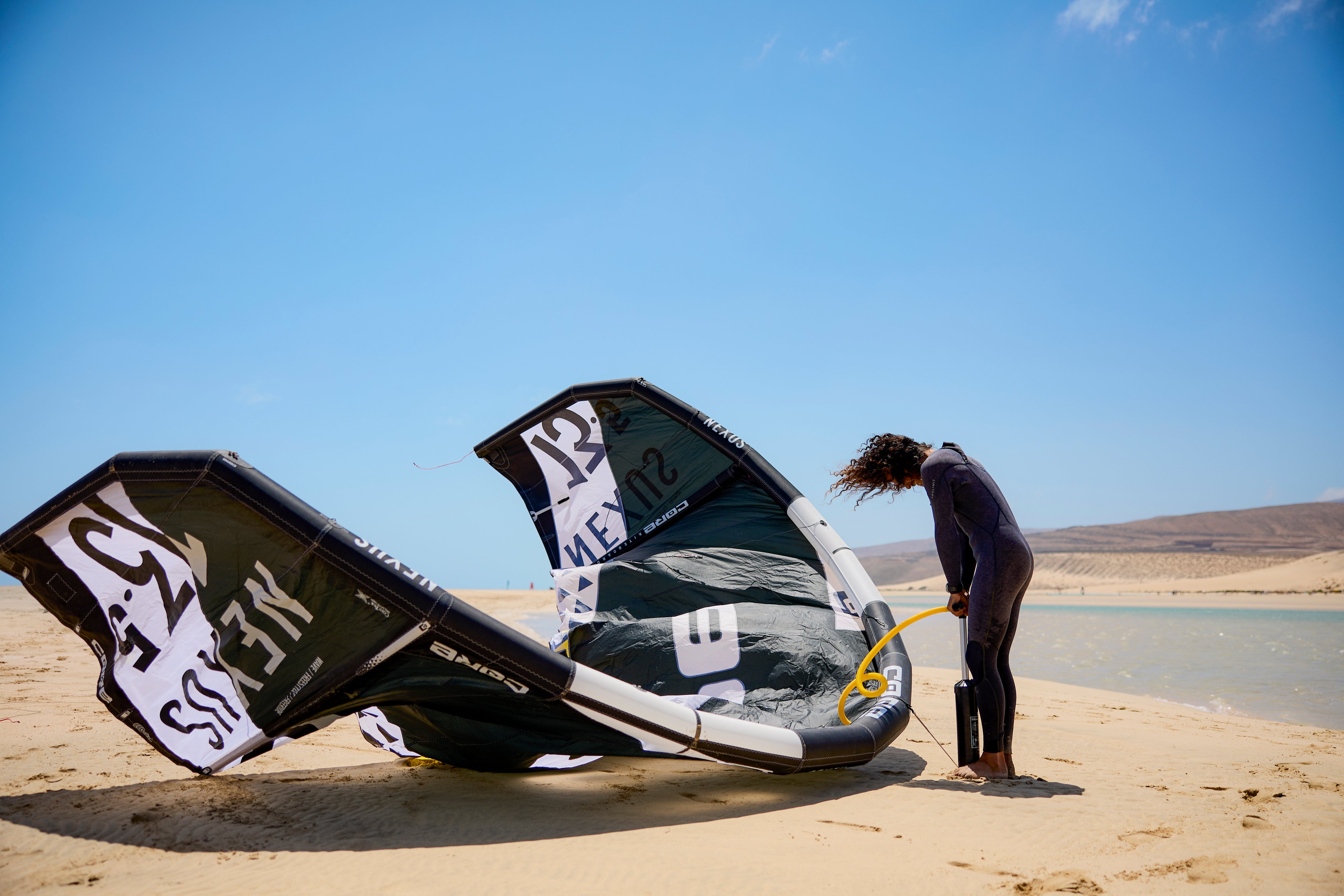 Ein Mensch bereitet beim Sonnen- und Windschutz einen Race-Kitesurf zu.