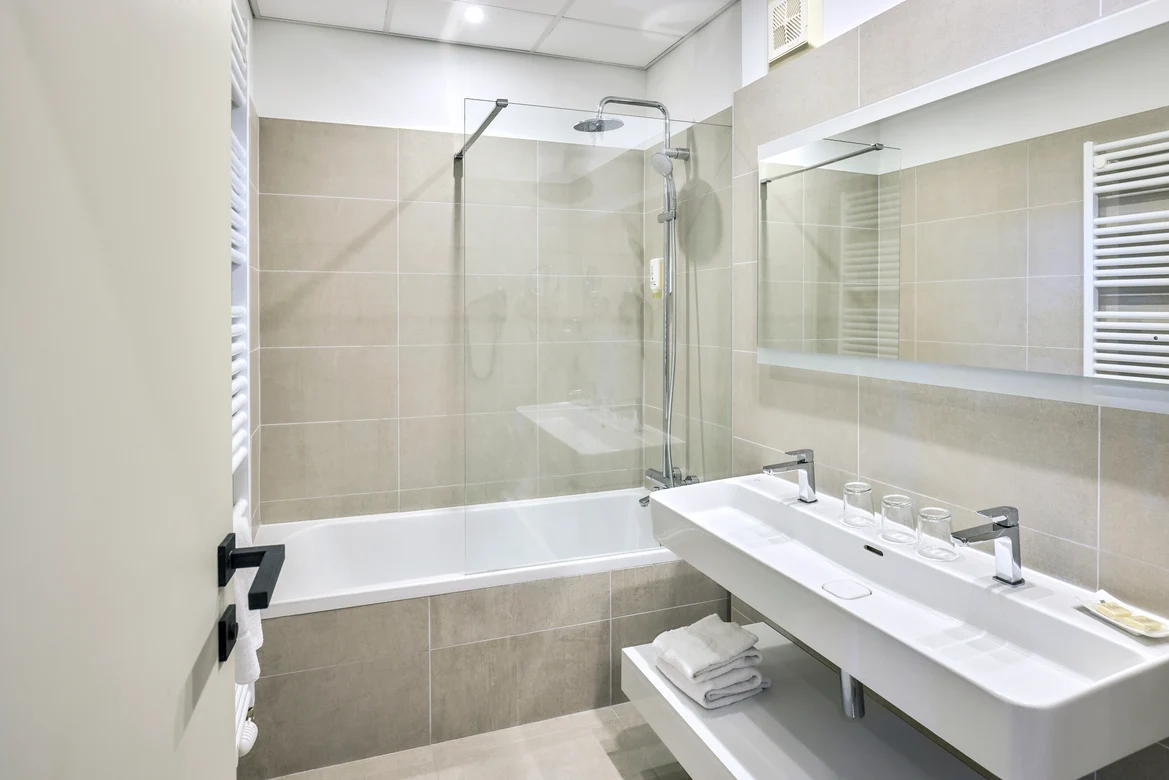 Badezimmer mit Badewanne, Doppelwaschbecken und großem Spiegel im Premium Cluburlaub bei Aldiana