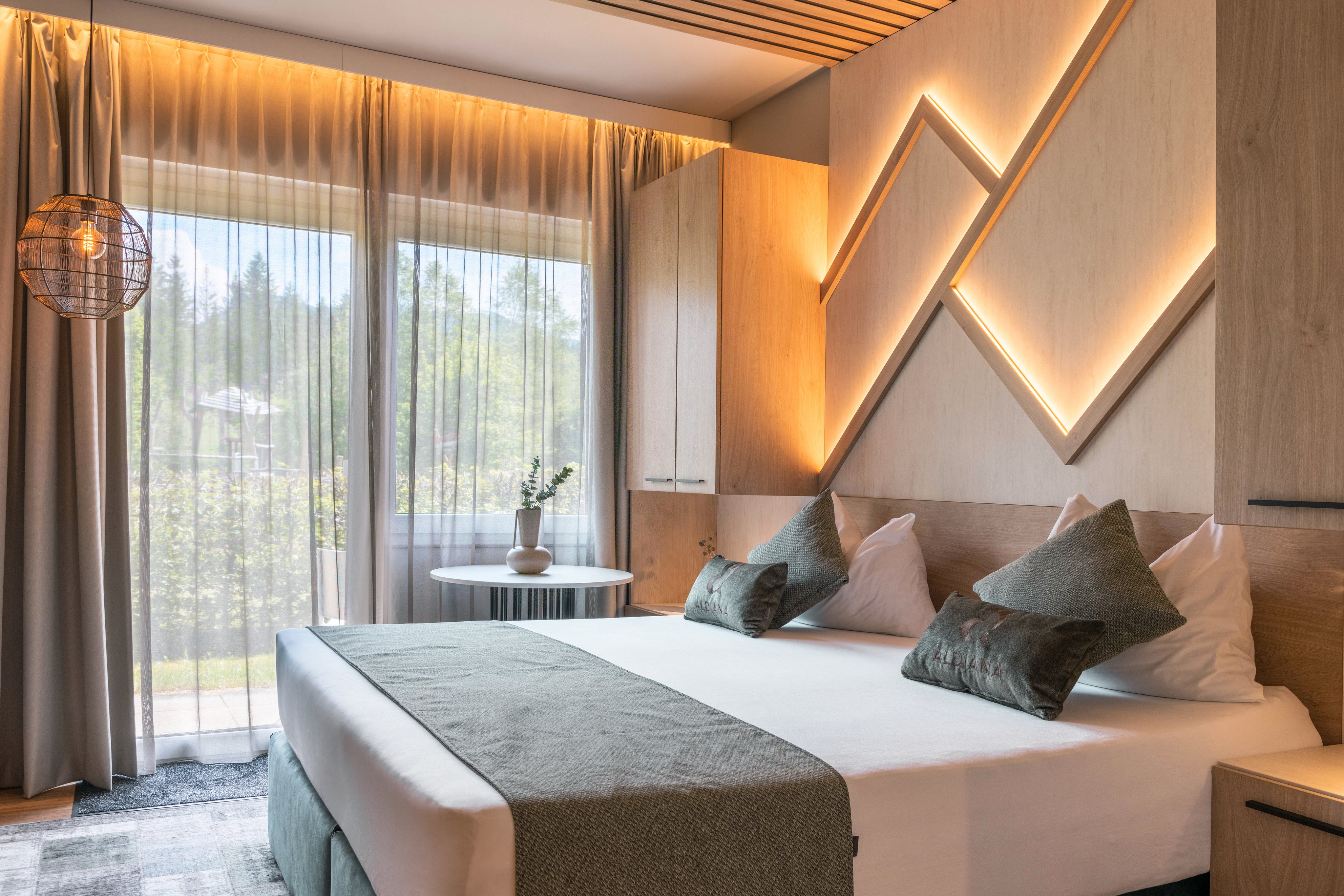 Modernes Hotelzimmer mit gemütlichem Bett, großen Fenstern und angenehmer Atmosphäre