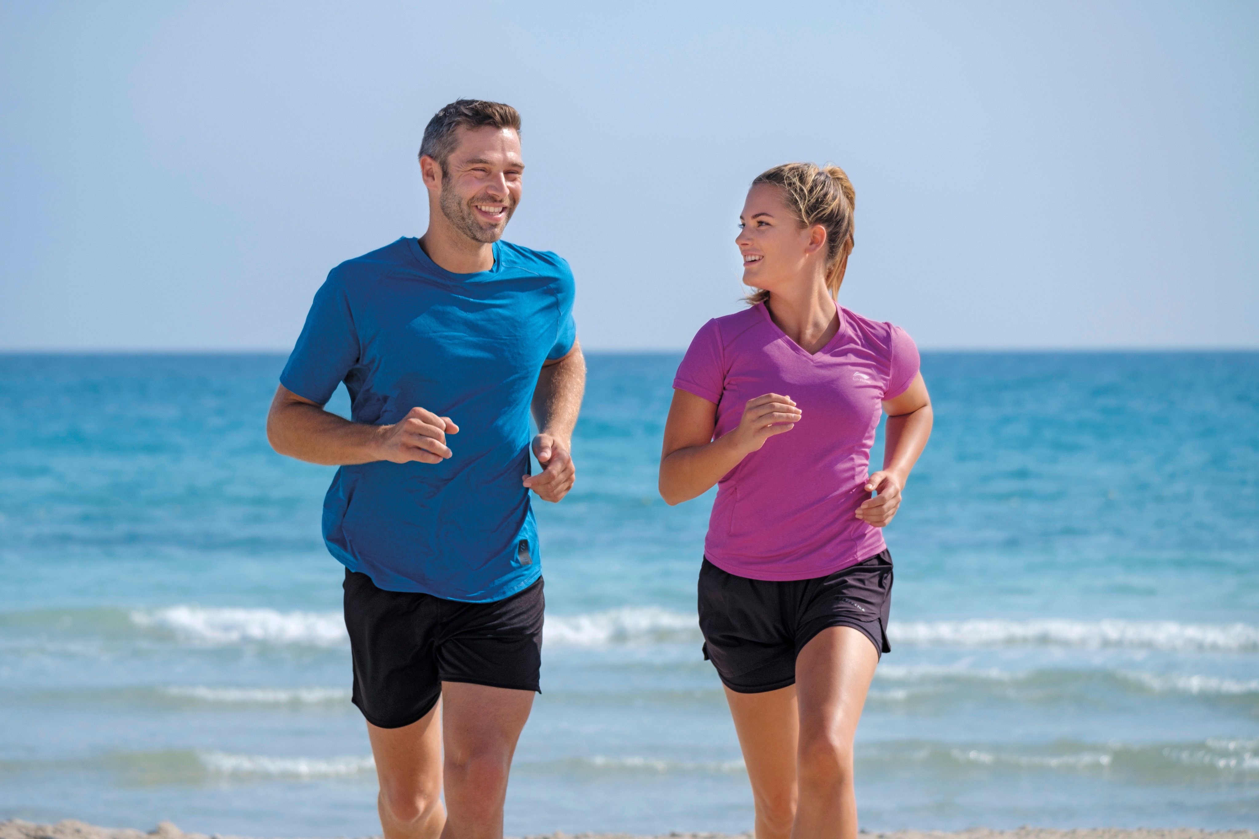 Zwei Menschen laufen am Strand entlang, genießen ihren Premium Cluburlaub bei Aldiana