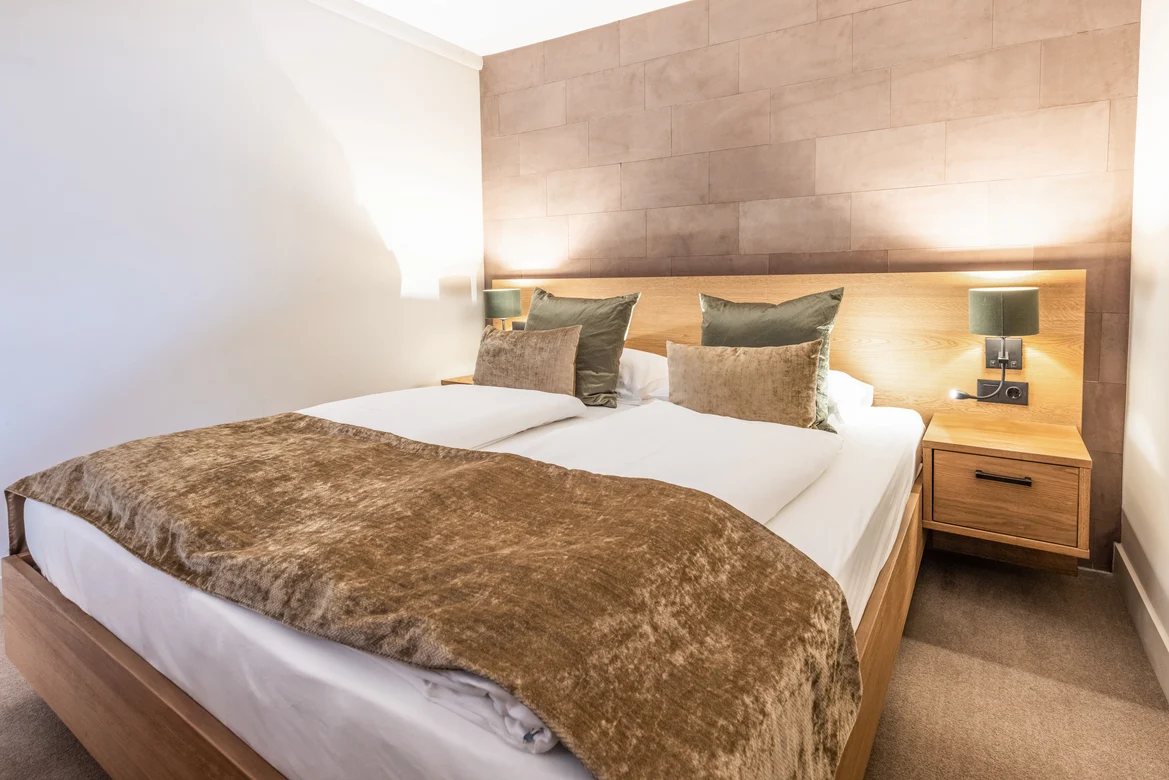 Modern Hotelzimmer mit gemütlichem Bett, weicher Bettdecke und stilvoller Beleuchtung