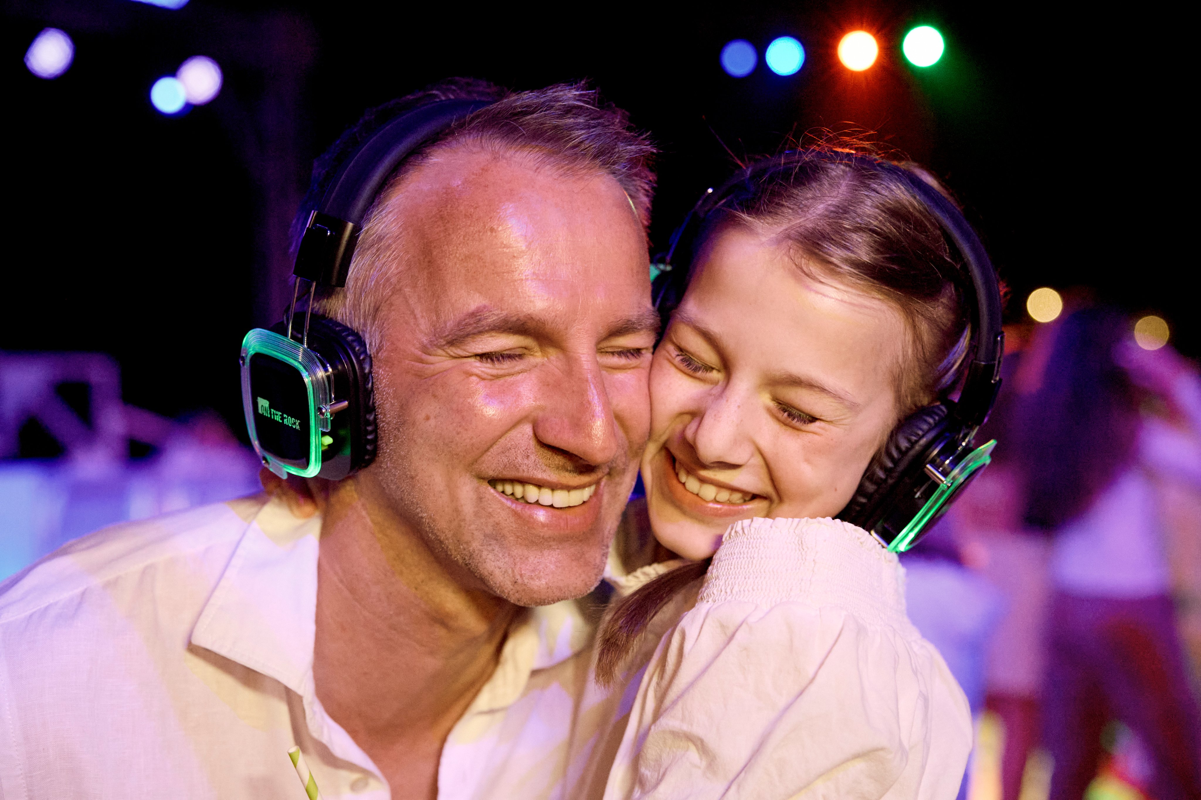 Zwei Menschen mit Kopfhörern bei einem Premium Aldiana Cluburlaub, feiern am Abend