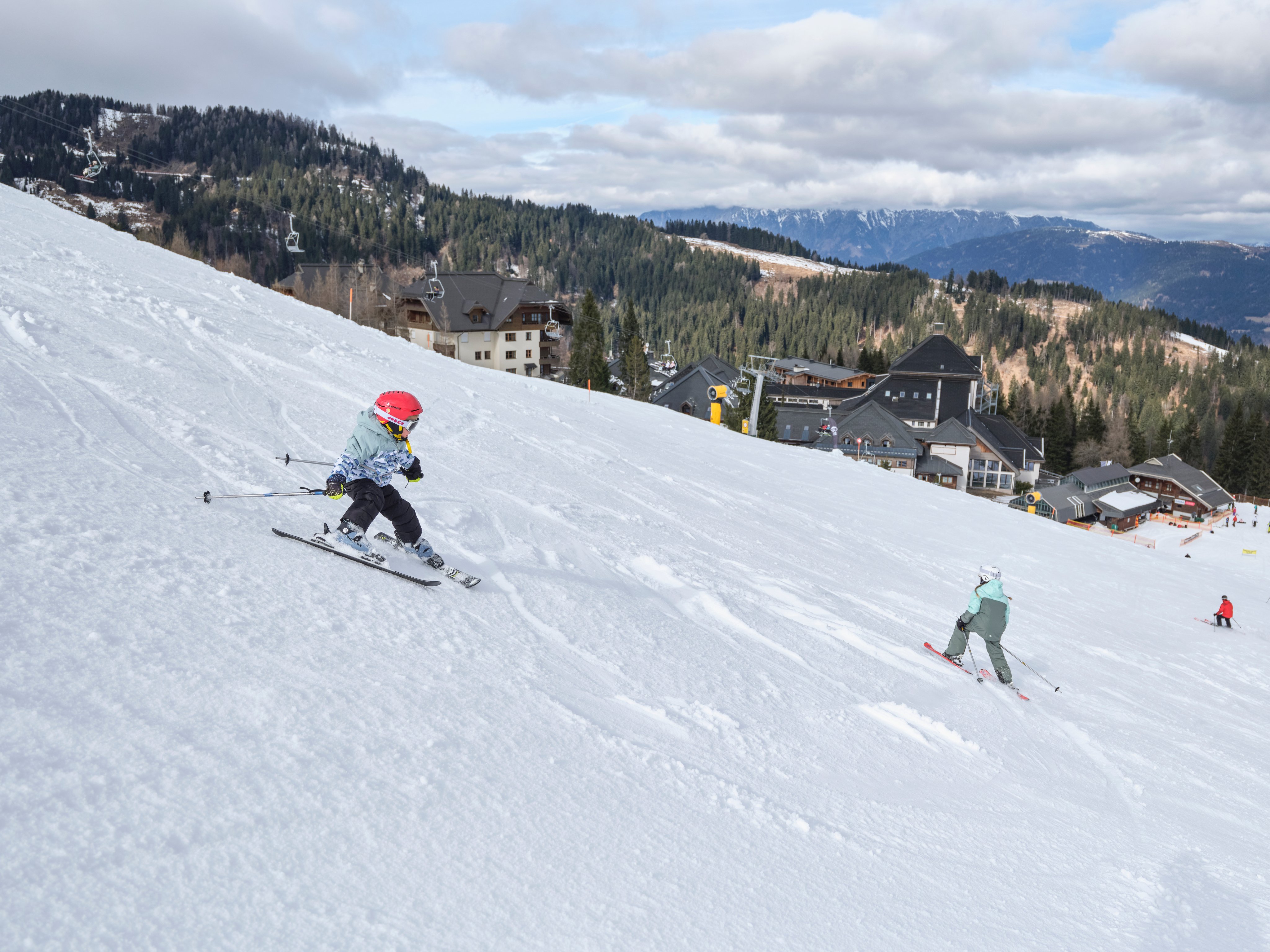 Skifahrer auf verschneiter Piste bei Aldiana Premium Cluburlaub, Bergkulisse im Hintergrund
