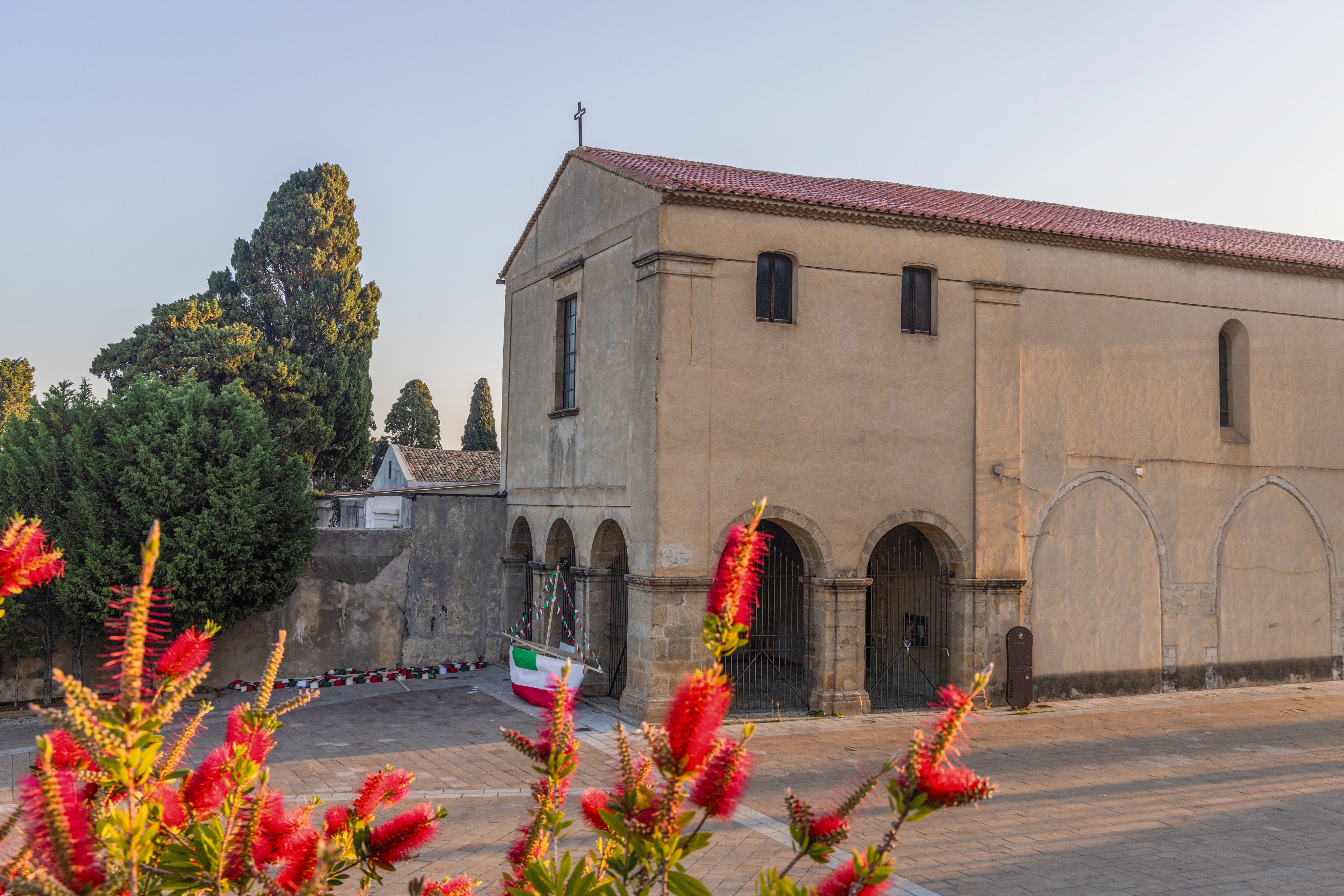 Altdiana Kirche mit roten Flammenpflanzen im Vordergrund, barrierefreies Premium Cluburlaub Gebiet