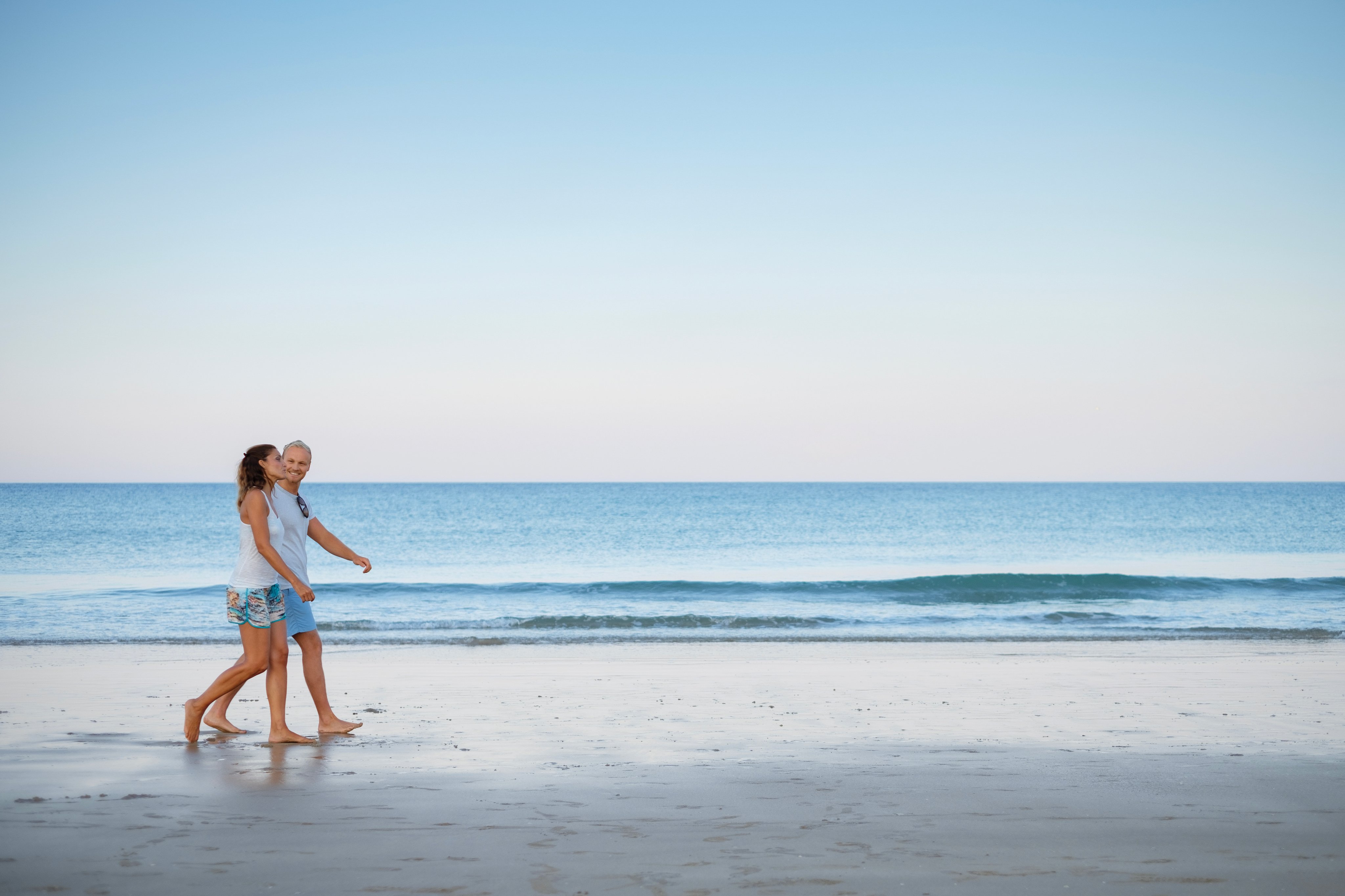 Zwei Frauen spazieren am Strand entlang im Premium Cluburlaub von Aldiana