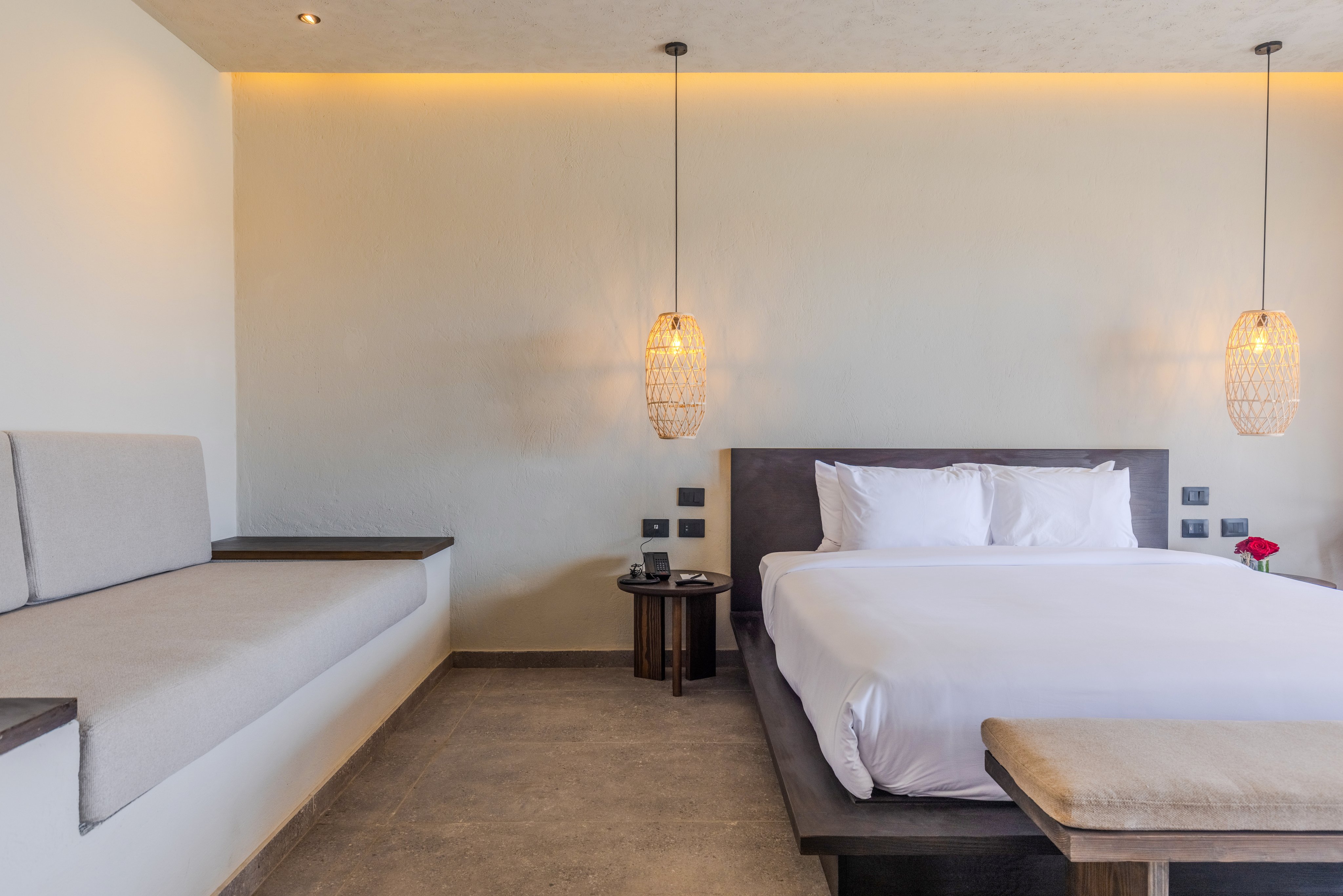 Aldiana Hotel Doppelzimmer mit Bett, Nachttischen und moderner Beleuchtung.