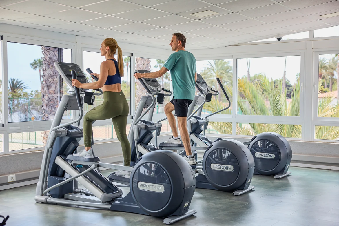 2 Personen auf Crosstrainern im Fitness Studio