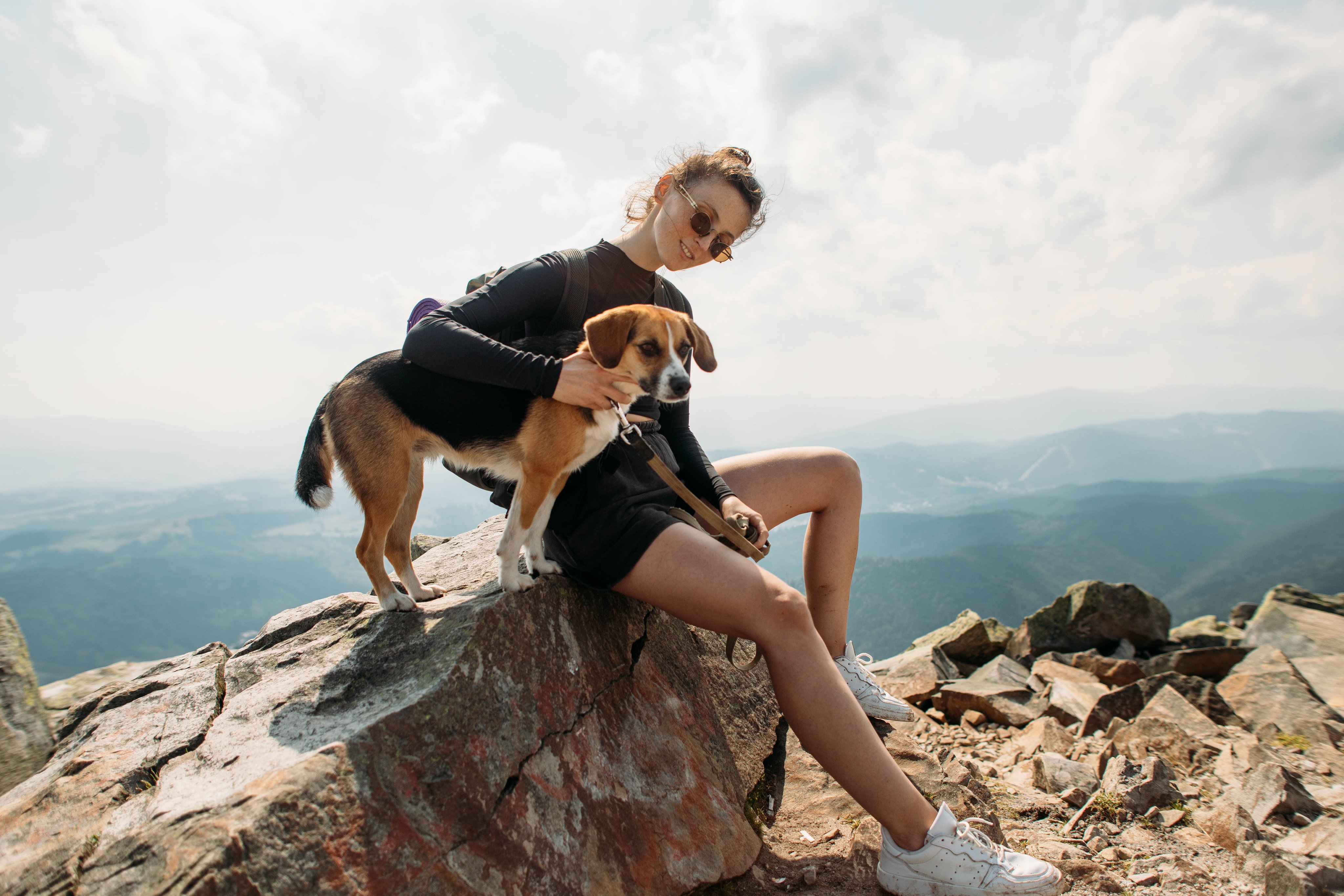 Eine Person mit Hund auf Berg auf einem Felsen, Natur, Wolken, Premium Cluburlaub.