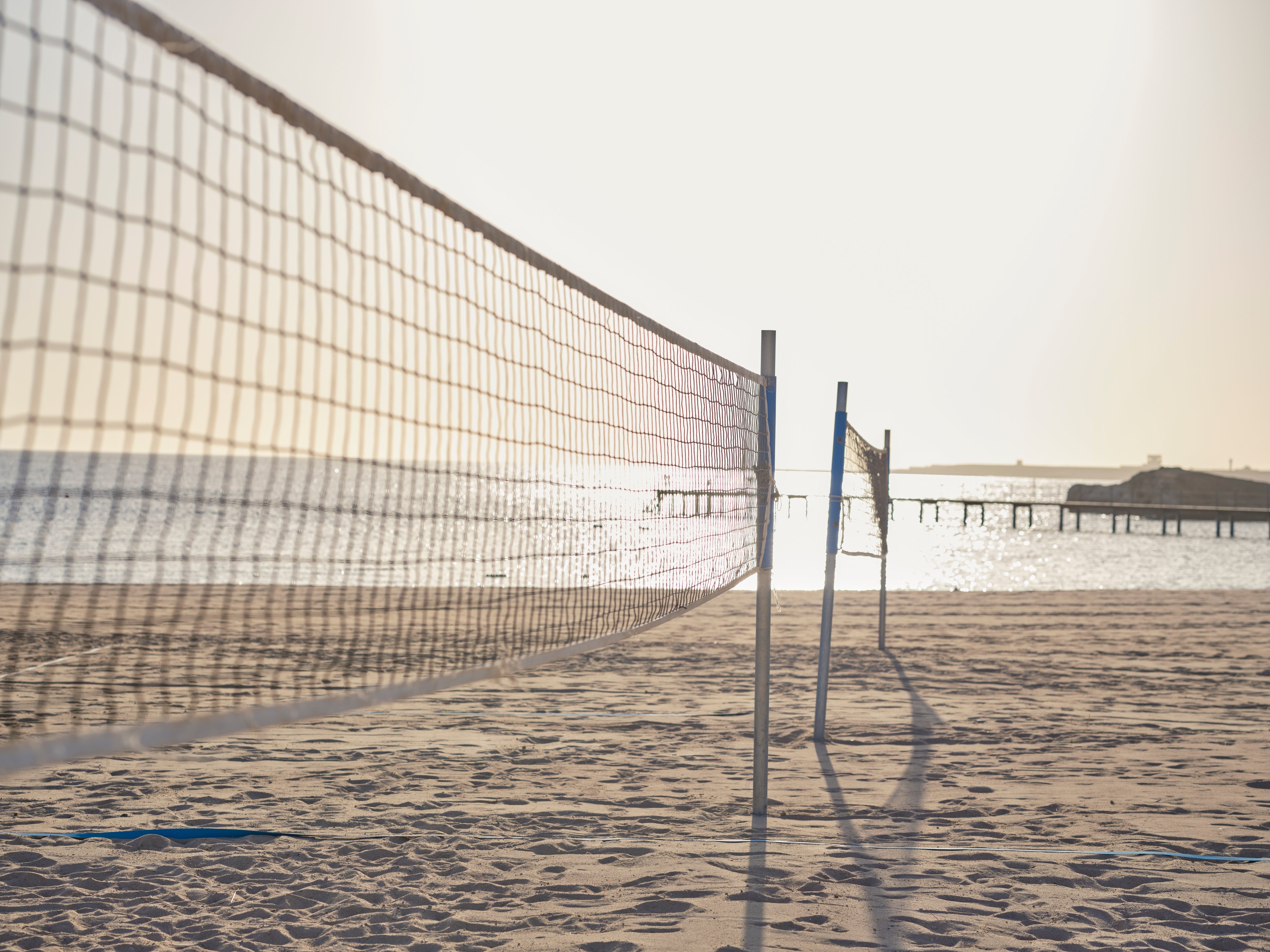 Leerer Strand mit Volleyballnetz bei Sonnenuntergang, entspannter Urlaub bei Aldiana