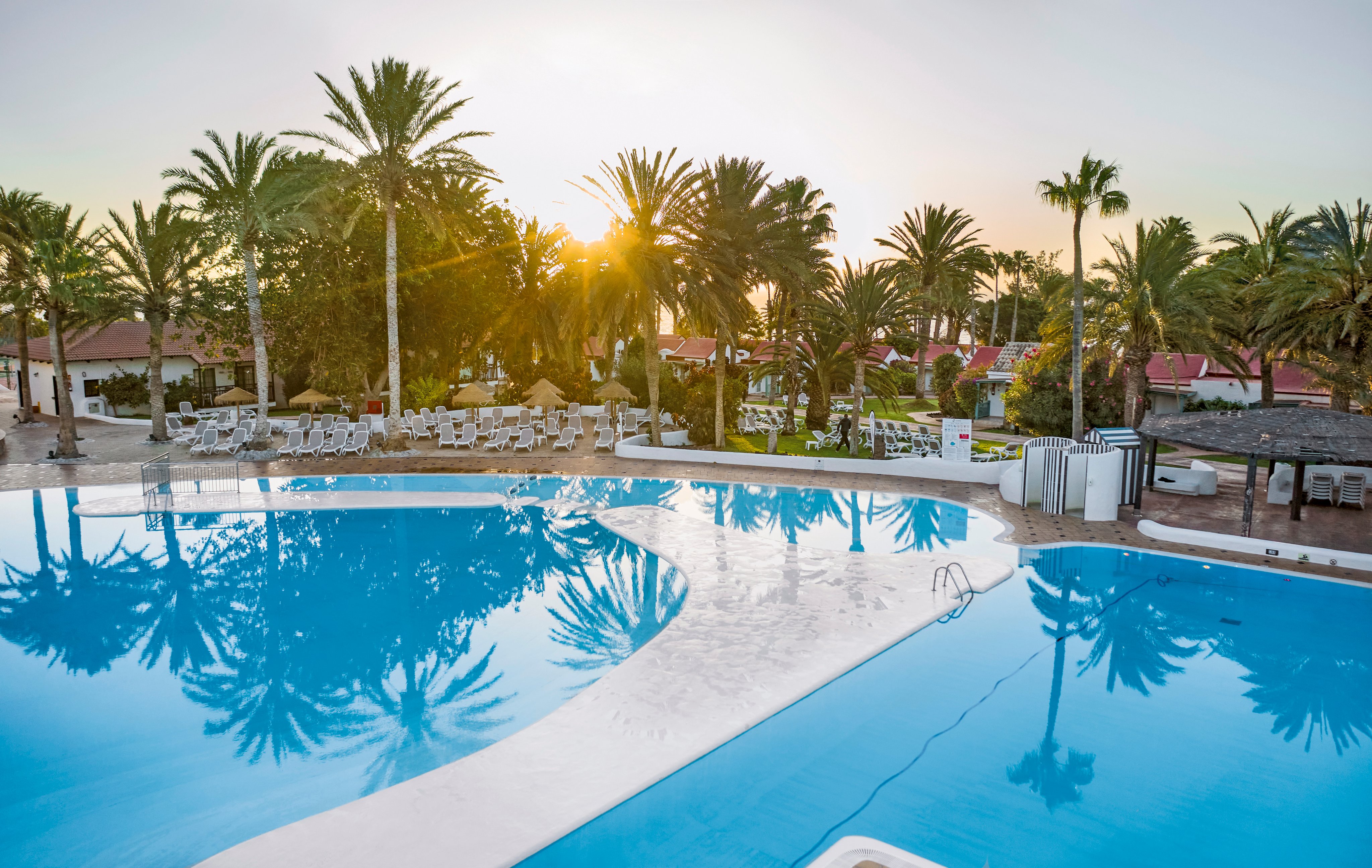 Entspannter Poolbereich bei Sonnenuntergang im Premium Cluburlaub von Aldiana