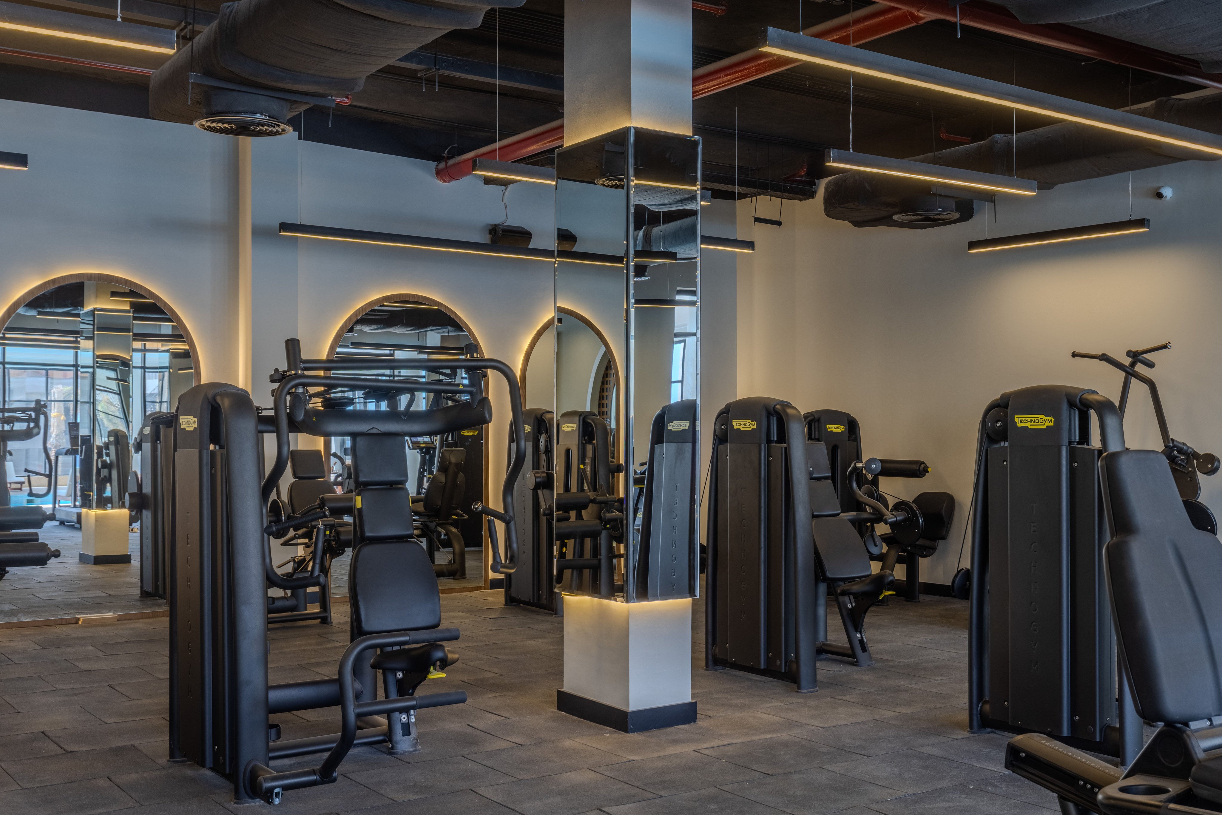 Modernes Fitnessstudio mit Fitnessgeräten im Premium Cluburlaub von Aldiana, hell beleuchtet.