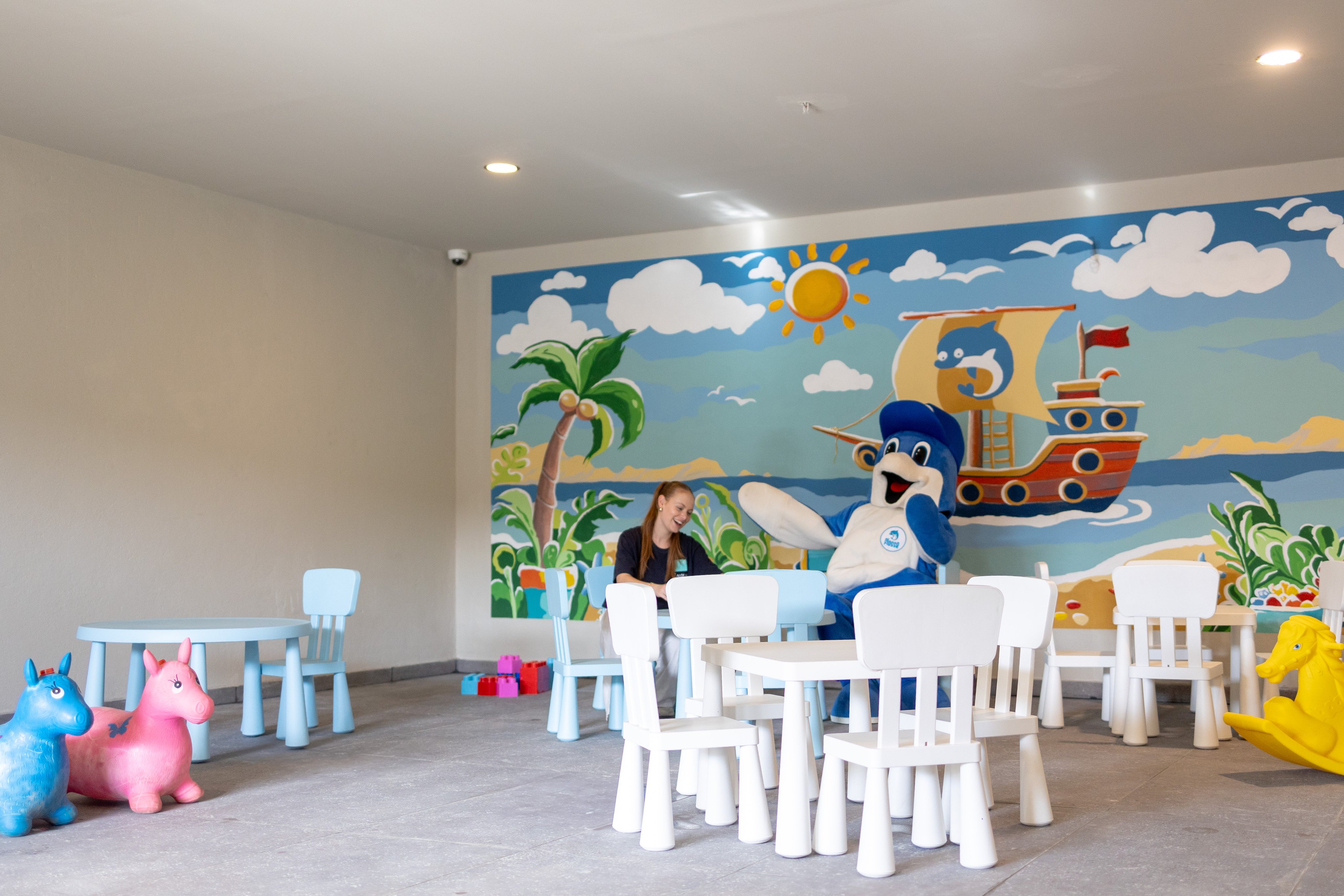 Kinder spielen im Spielraum mit bunter Meeresmischung und einem großen Wandbild