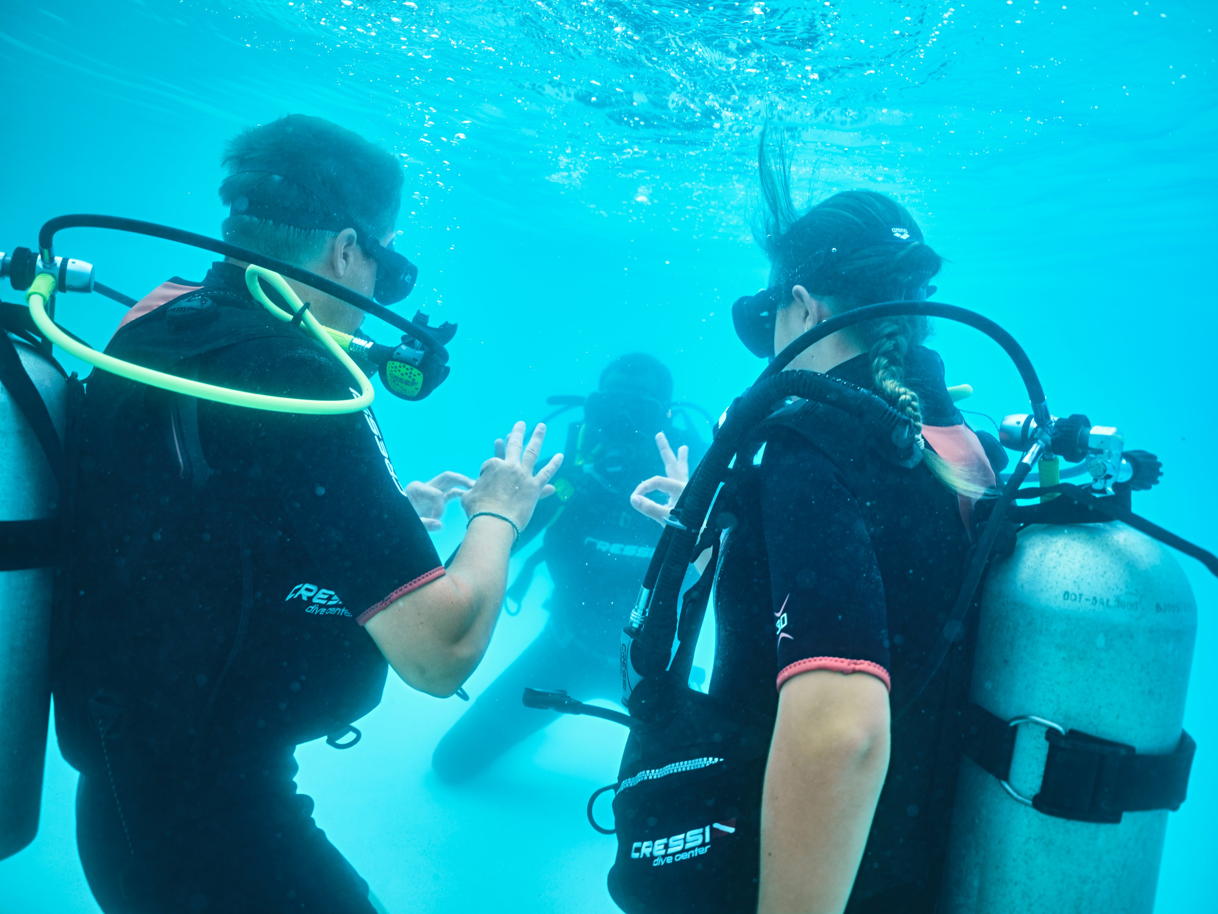 Zwei Taucher im klaren Wasser beim Gespräch, hochwertige Tauchausrüstung, Aldiana Premium Urlaub