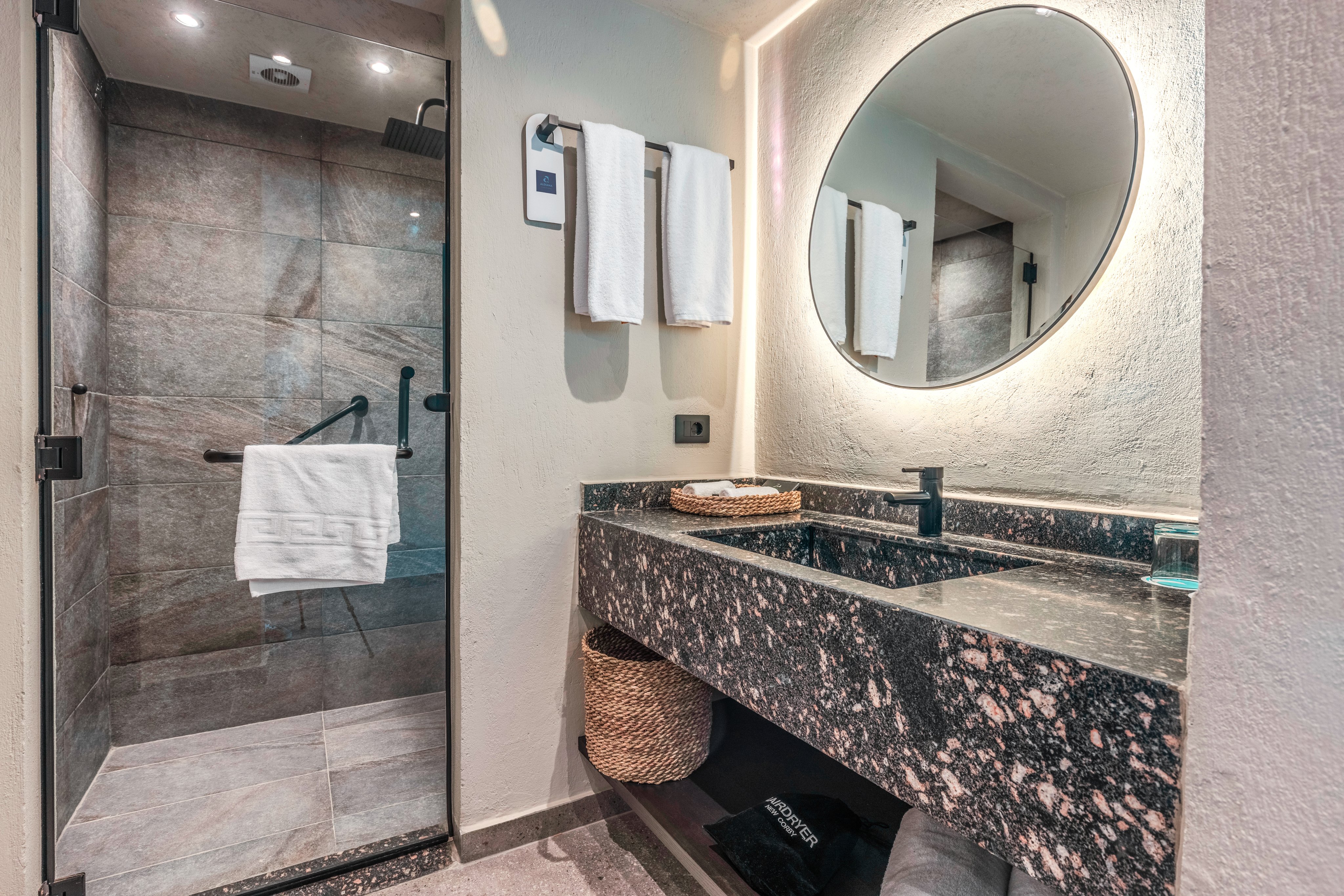 Modernes Badezimmer mit Waschbecken, Spiegel und Handtuchhalter, barrierefreie Ausstattung.