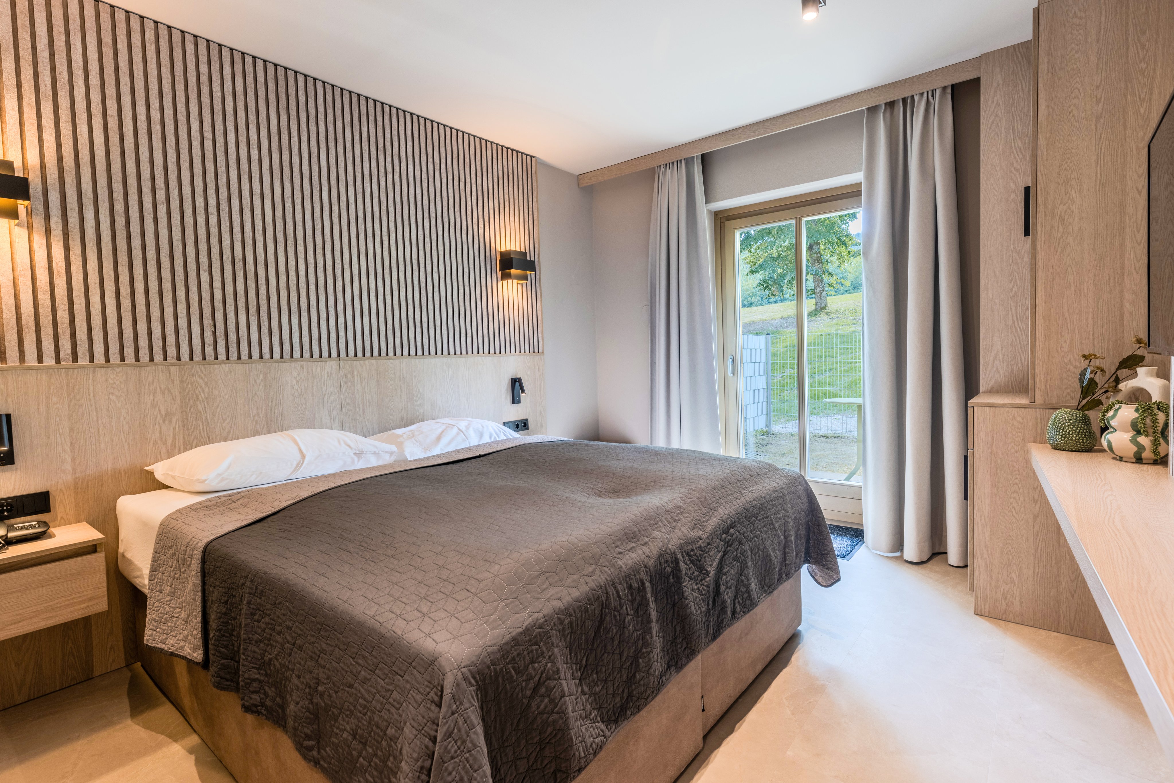 Ein gemütliches Hotelzimmer bei Aldiana mit Doppelbett, moderner Einrichtung und Balkonblick