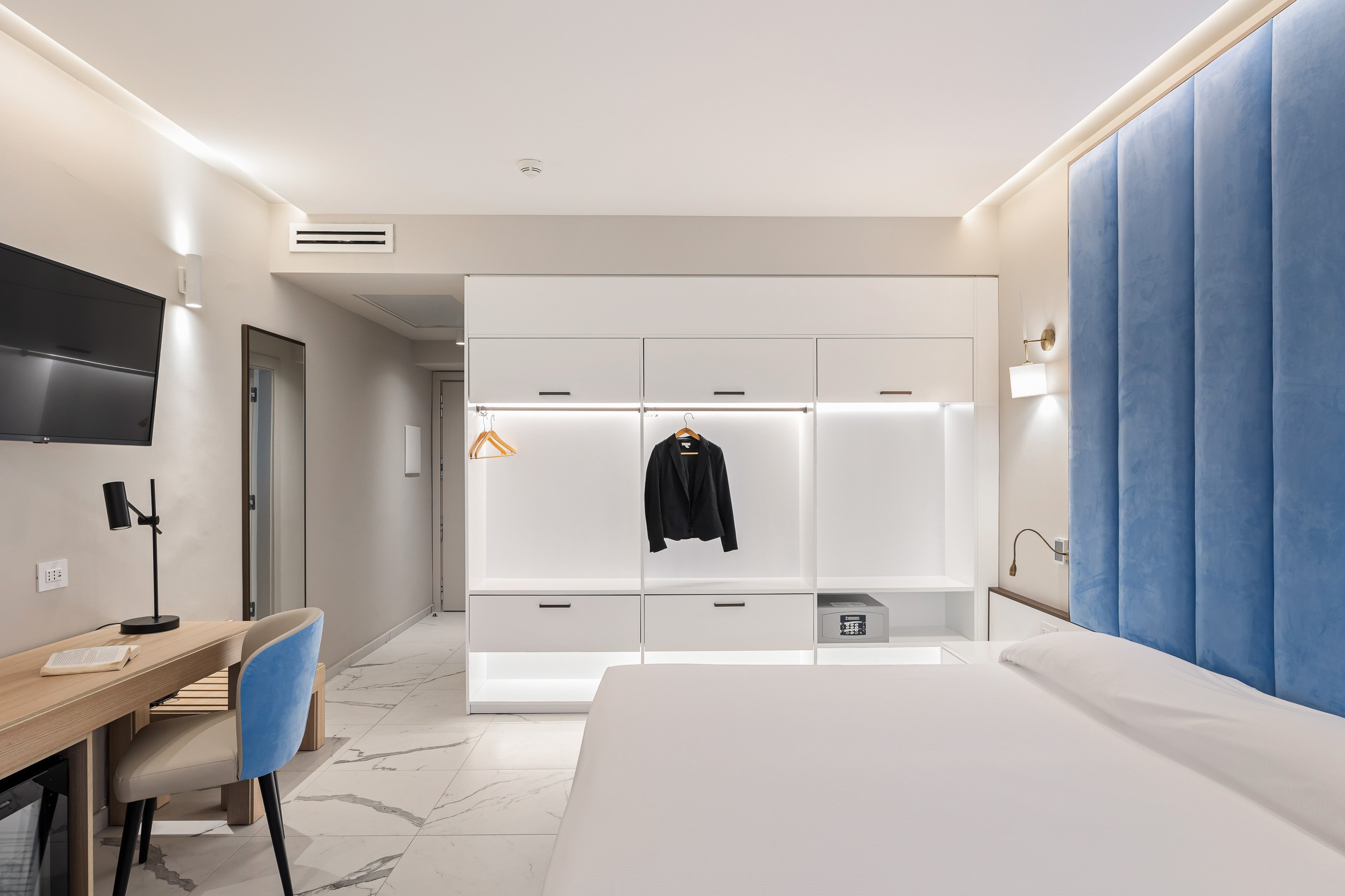 Modernes Hotelzimmer bei Aldiana mit weißem Schrank und blauer Wandvertäfelung