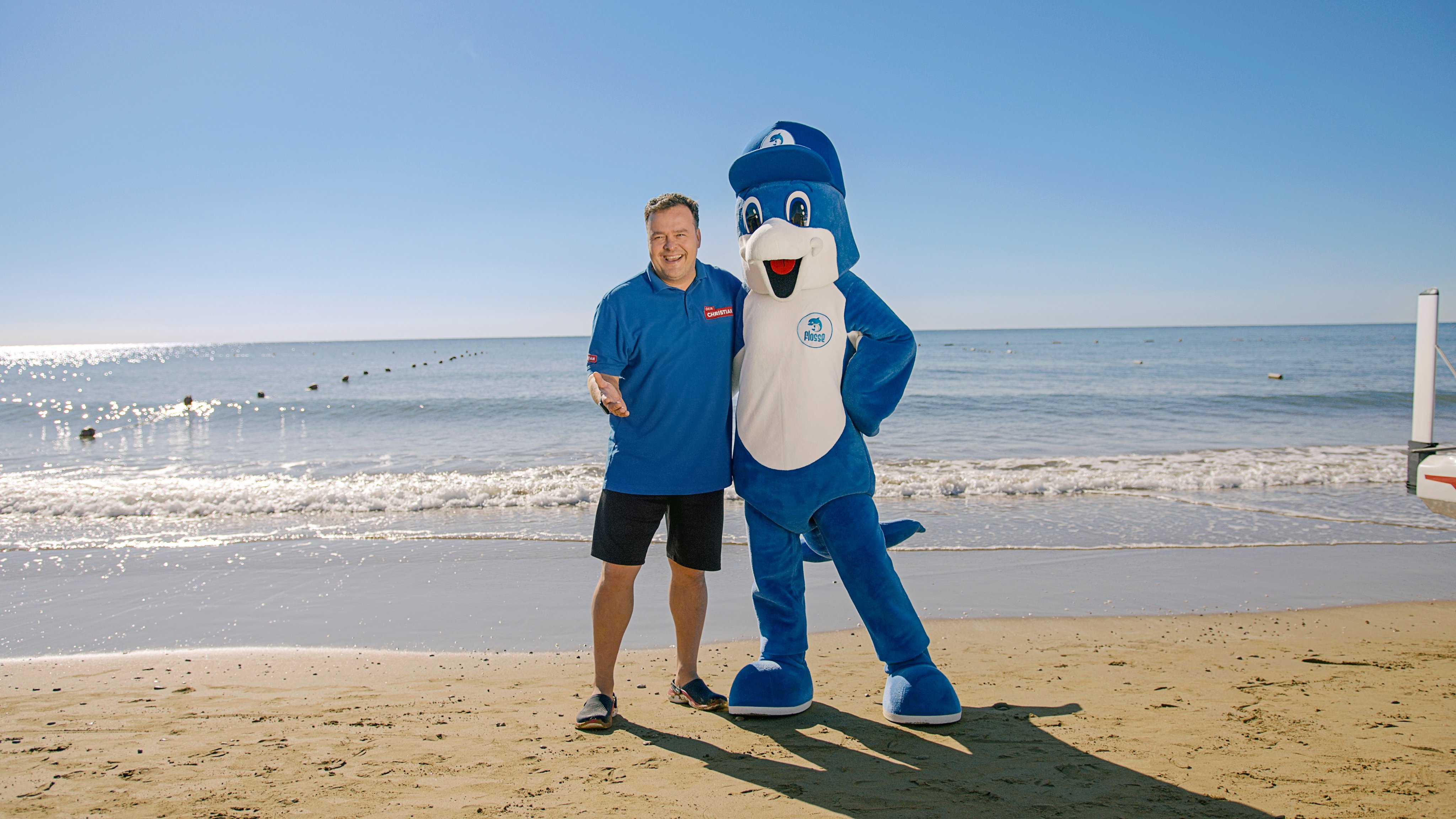 Person am Strand mit Maskottchen bei Aldiana Premium Cluburlaub