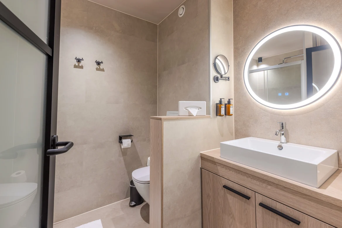 Modernes Badezimmer mit flacher Dusche, Waschbecken und Spiegel im Premium Cluburlaub von Aldiana