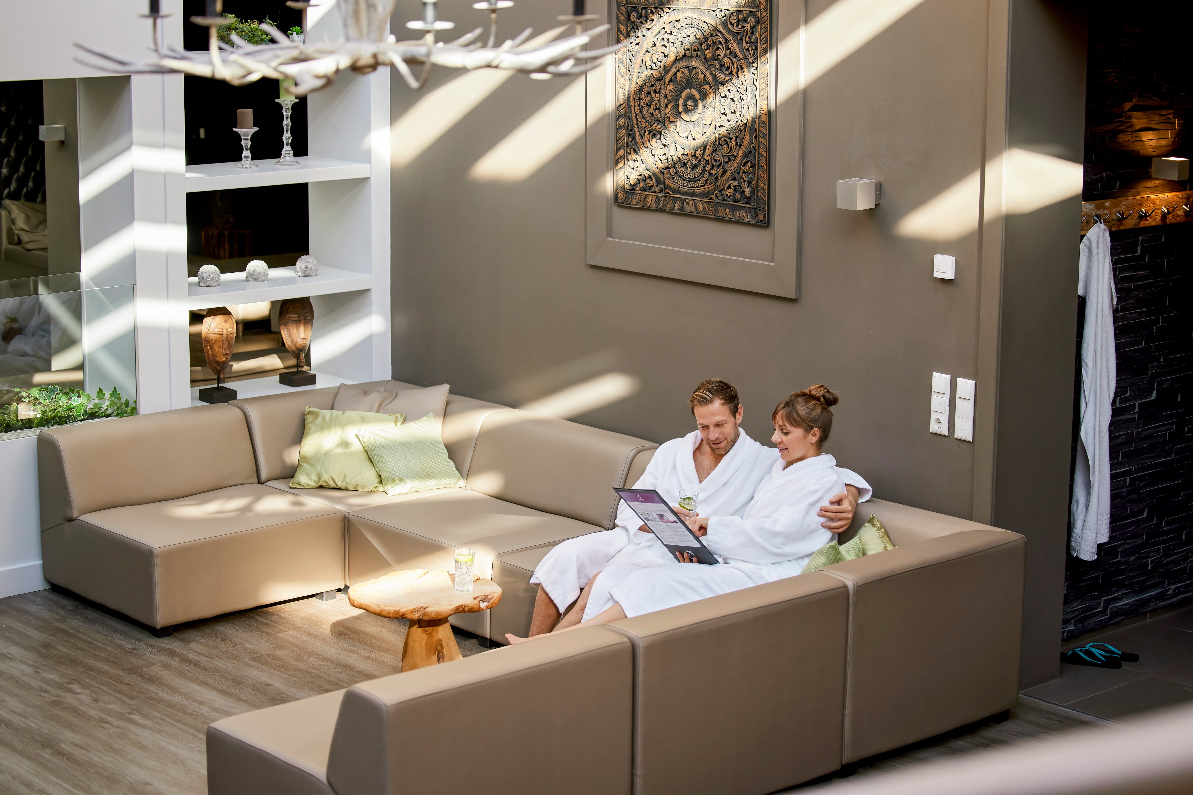 Zwei Personen im eleganten Wohnzimmer entspannen auf einem großen beigen Sofa