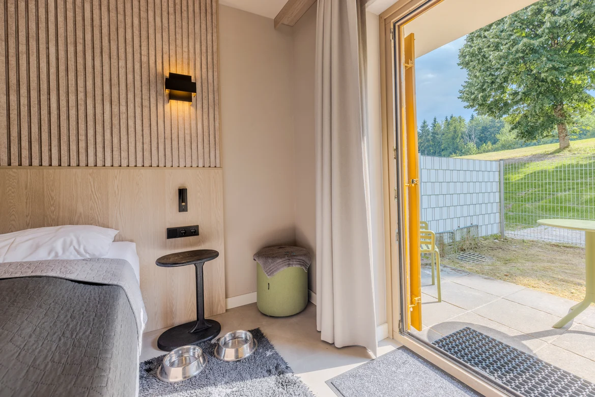 Ein Hotelzimmer bei Aldiana mit Bett, Nachttisch, Stuhl und Zugang zur Terrasse