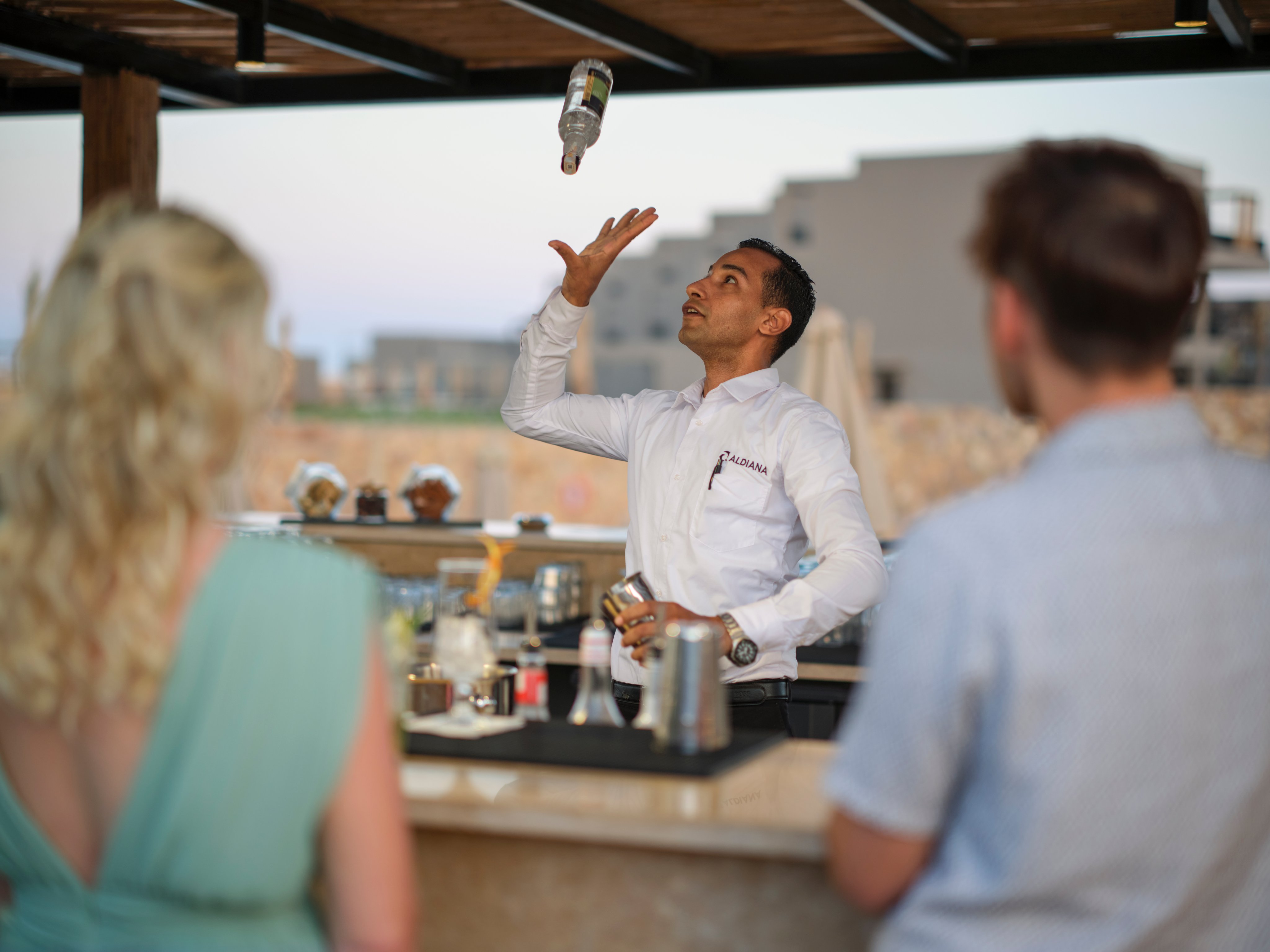 Menschen beim Barservice auf einer sonnigen Terrasse im Premium Cluburlaub bei Aldiana
