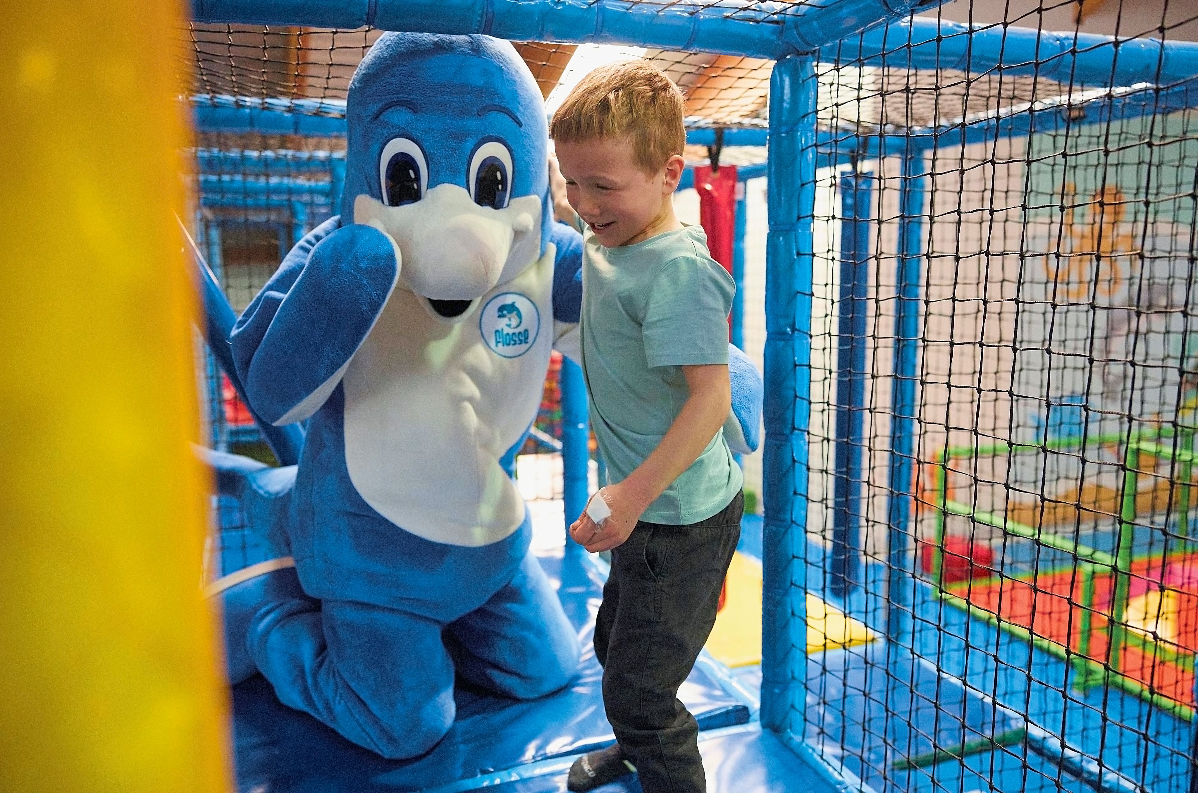 Kindergesicht mit blauer Delfin-Figur bei Aldiana im Indoor-Spielbereich