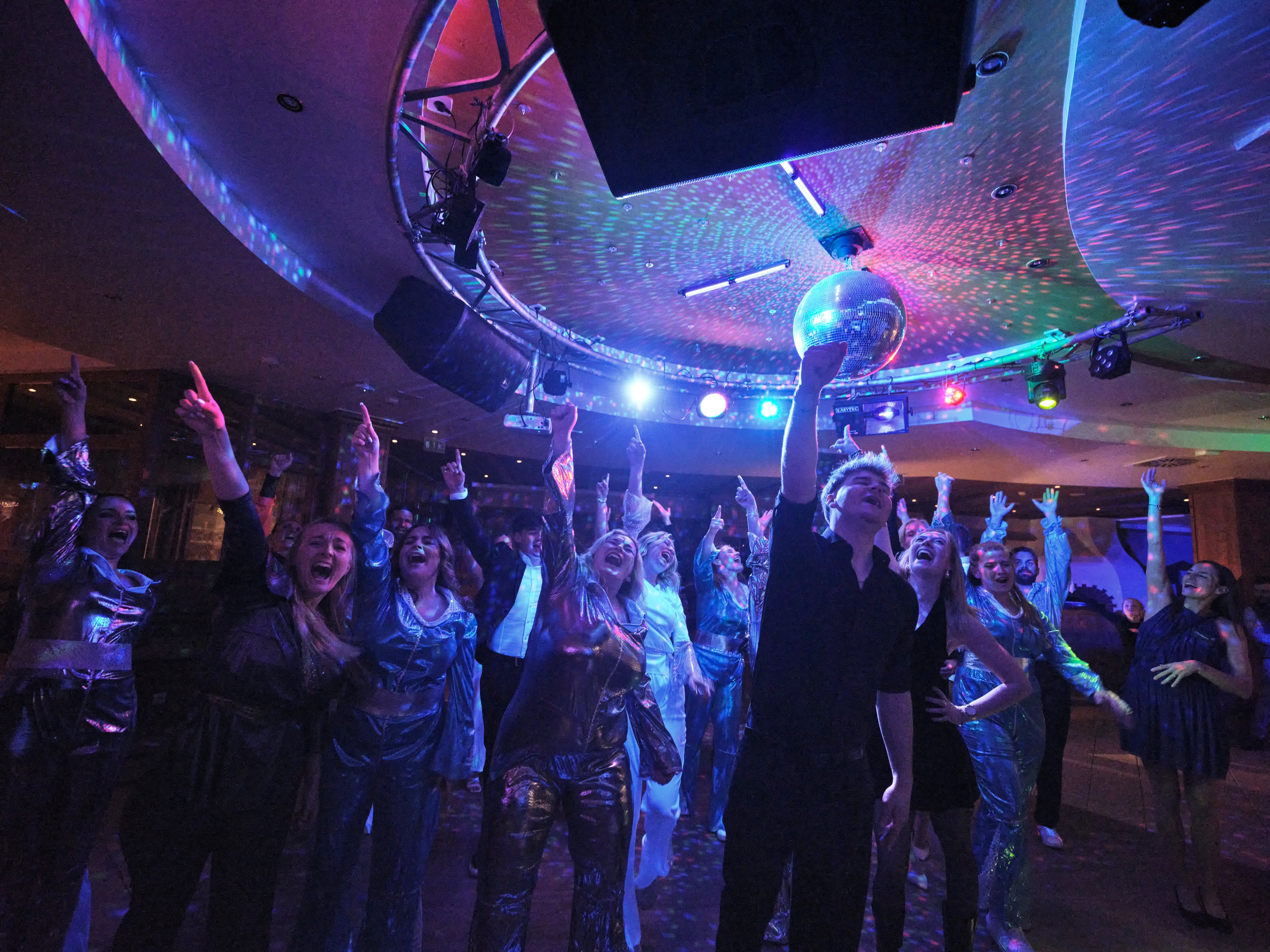 Tanzende Gäste bei einer Veranstaltung im Aldiana Club, bunte Lichter und Disco-Atmosphäre