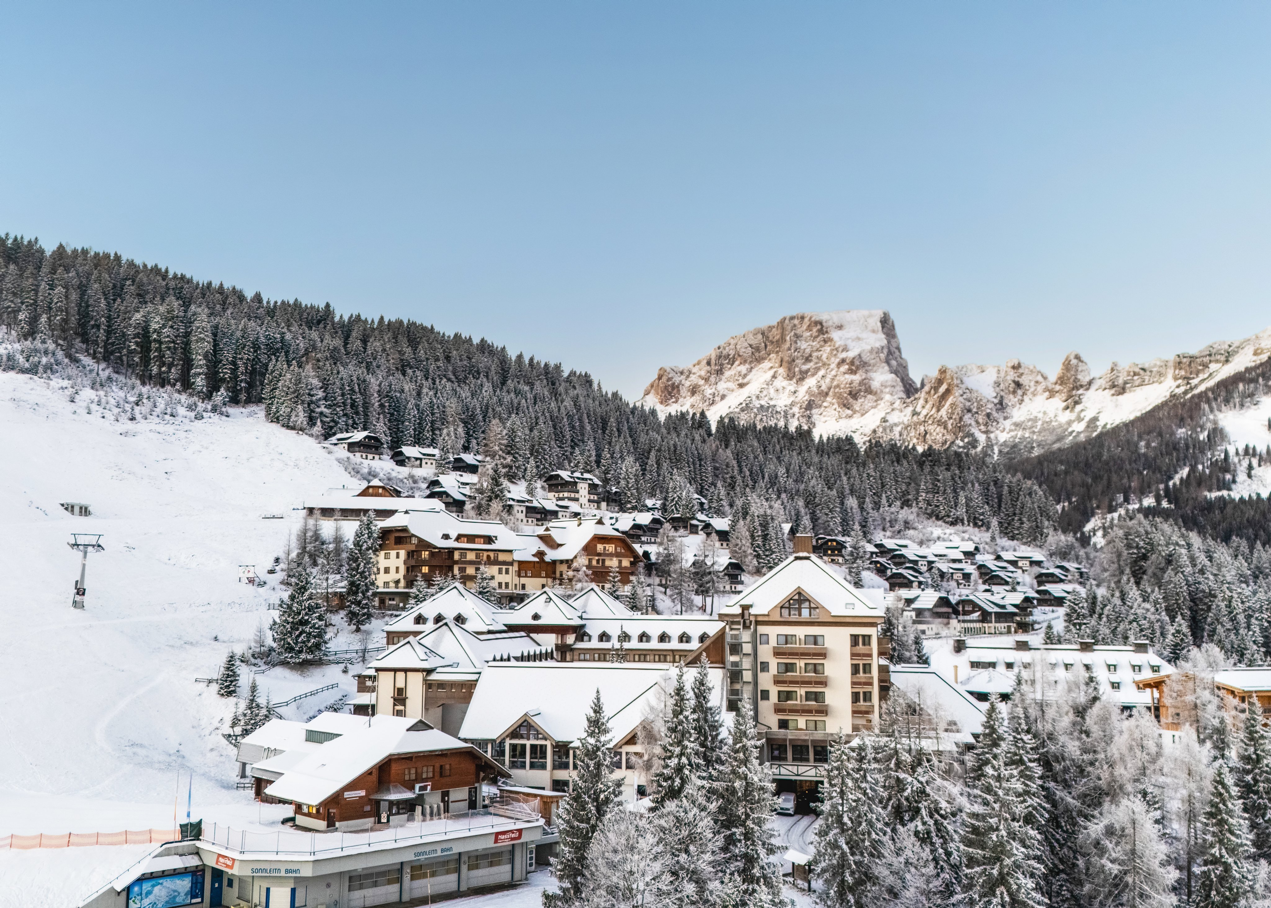 Höhenlage im Winter: Schneebedeckte Berge und alpine Hotelanlage bei Aldiana Urlaub