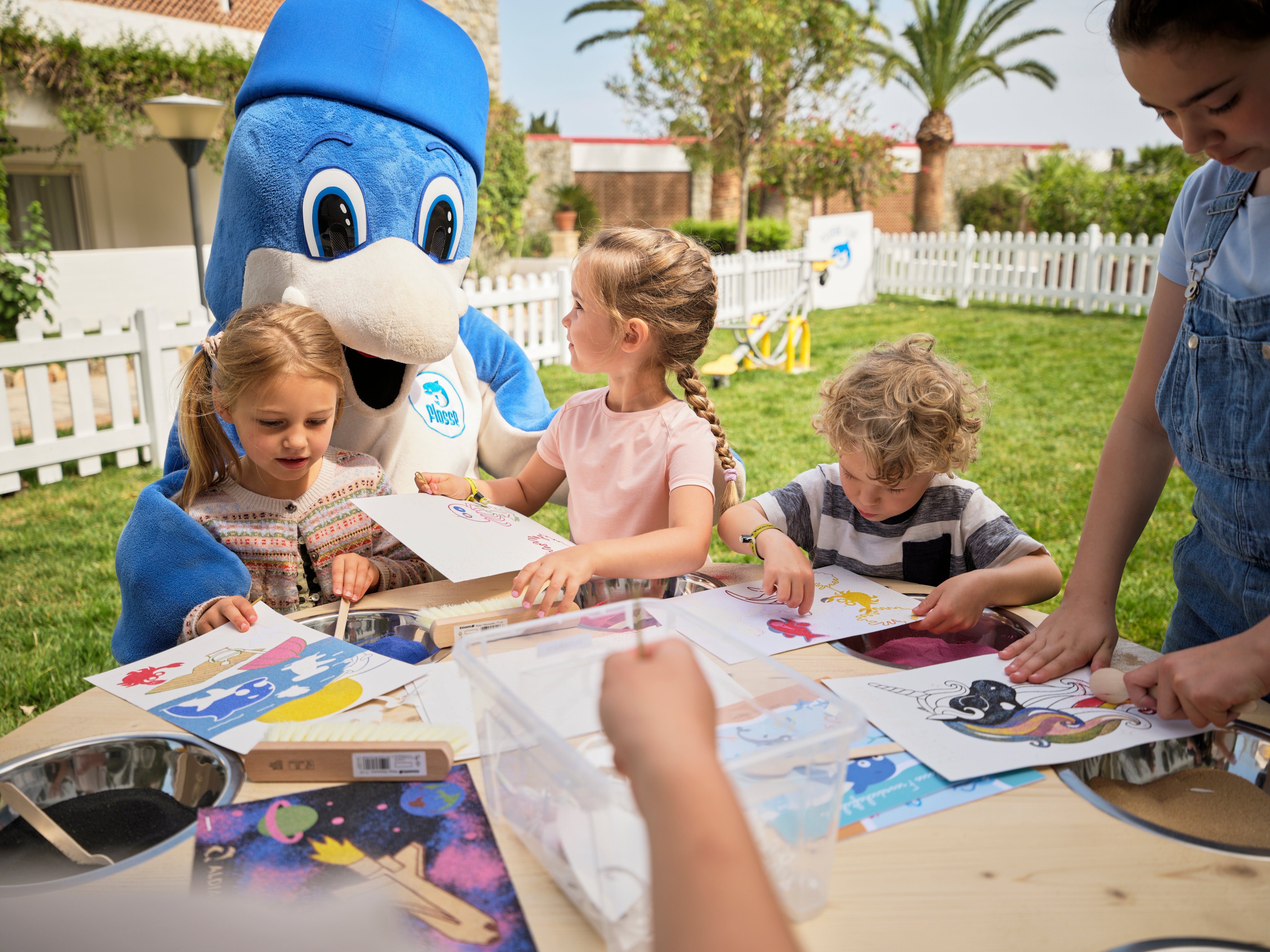 Kinder spielen mit Mascotte an einem sonnigen Tag im Garten, beim Freizeitprogramm bei Aldiana
