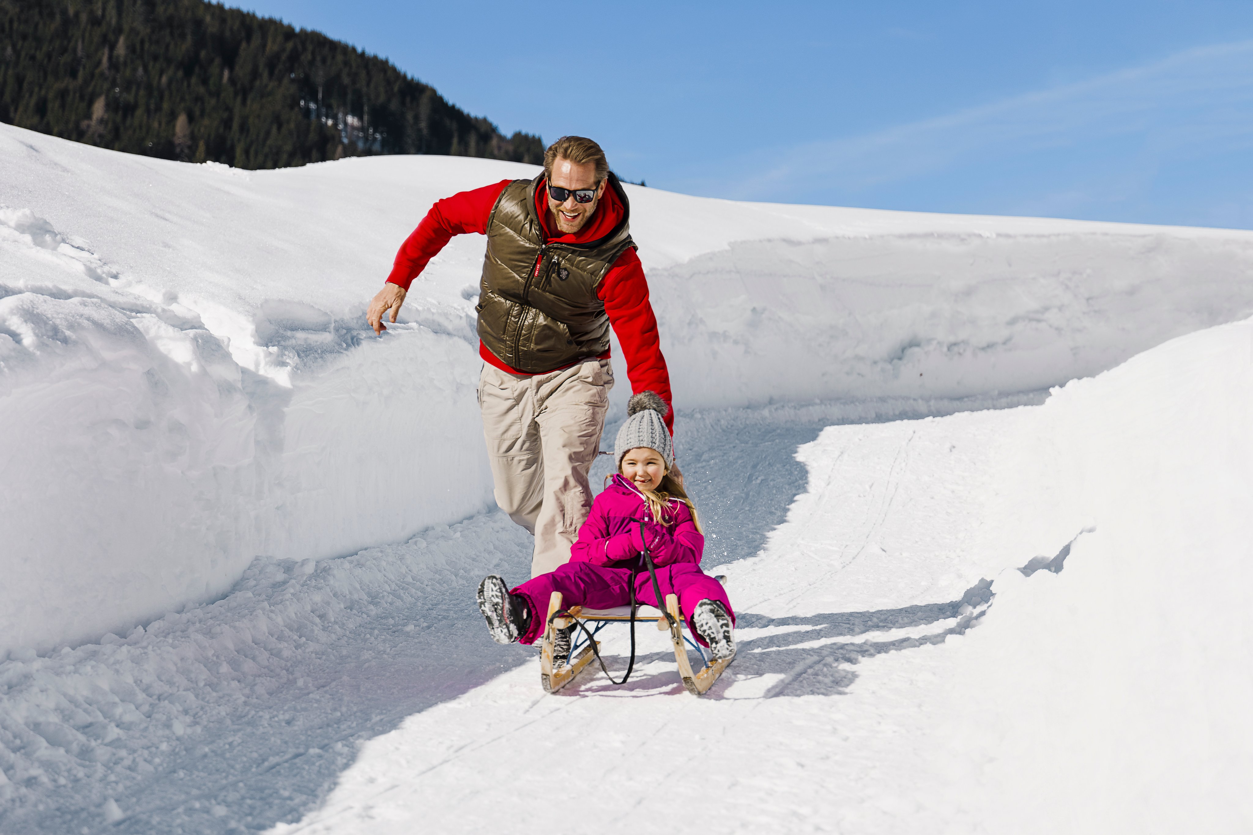 Familie beim Wintersport im Schnee, glücklich und aktiv, ideal für Premium Cluburlaub von Aldiana