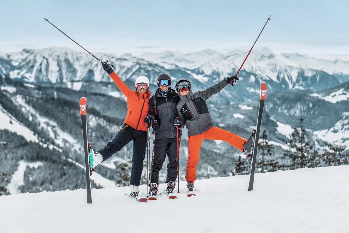 Drei Skifahrer auf Gipfel mit Bergpanorama, genießen Premium Cluburlaub bei Aldiana