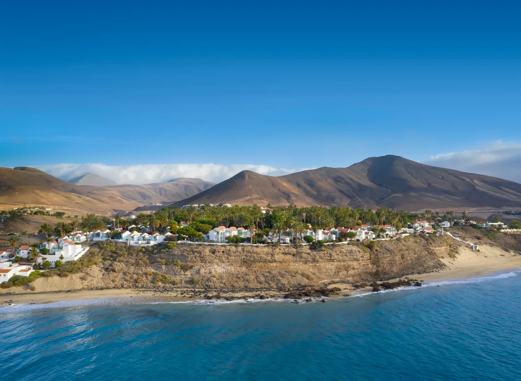 Aldiana Ferienclub am Strand mit Meerblick, umgeben von Bergen und Sonne.